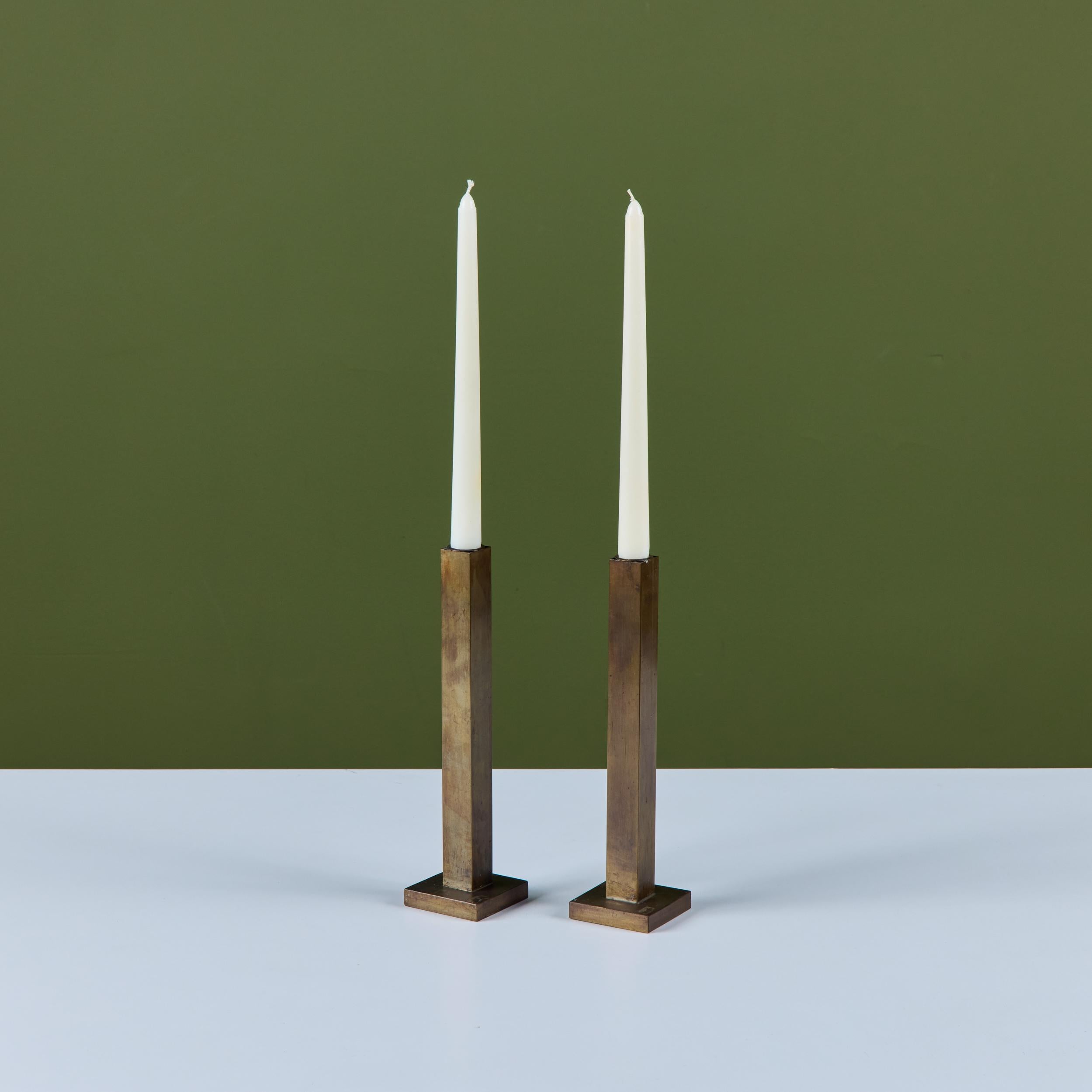 Pair of solid brass minimalist candlesticks by Canadian designer Martha Sturdy. The pair features a square tube stem on a square base. 
Labeled Martha Sturdy.

Dimensions
Each candlestick: 2.5