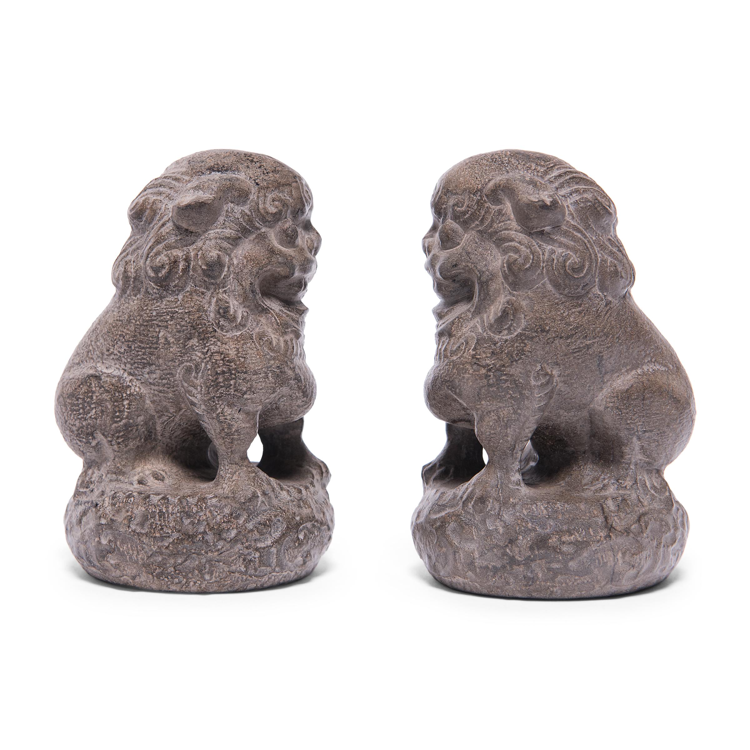 With curly manes and playful expressions, these petite stone fu dogs are adorable companions and benevolent guardians of the home. Also known as shizi, the pair represents yin and yang, and they sit in mirrored reclining postures on studded round
