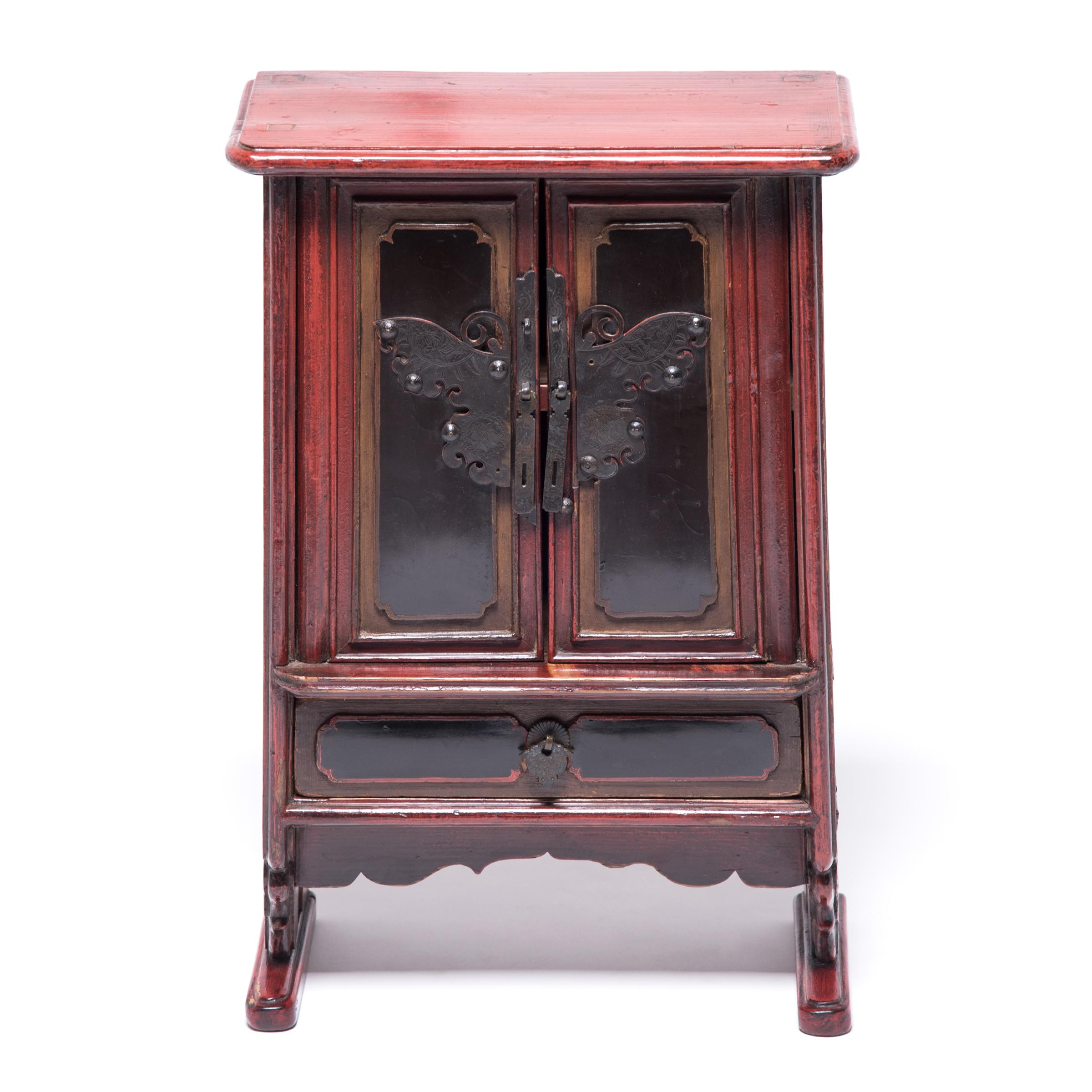 These late 19th century miniature tapered cabinets would have been kept in a woman's quarters, likely used as a jewelry box or cosmetics case. The carved door fronts are decorated with etched brass hardware in the shape of a butterfly, symbols of