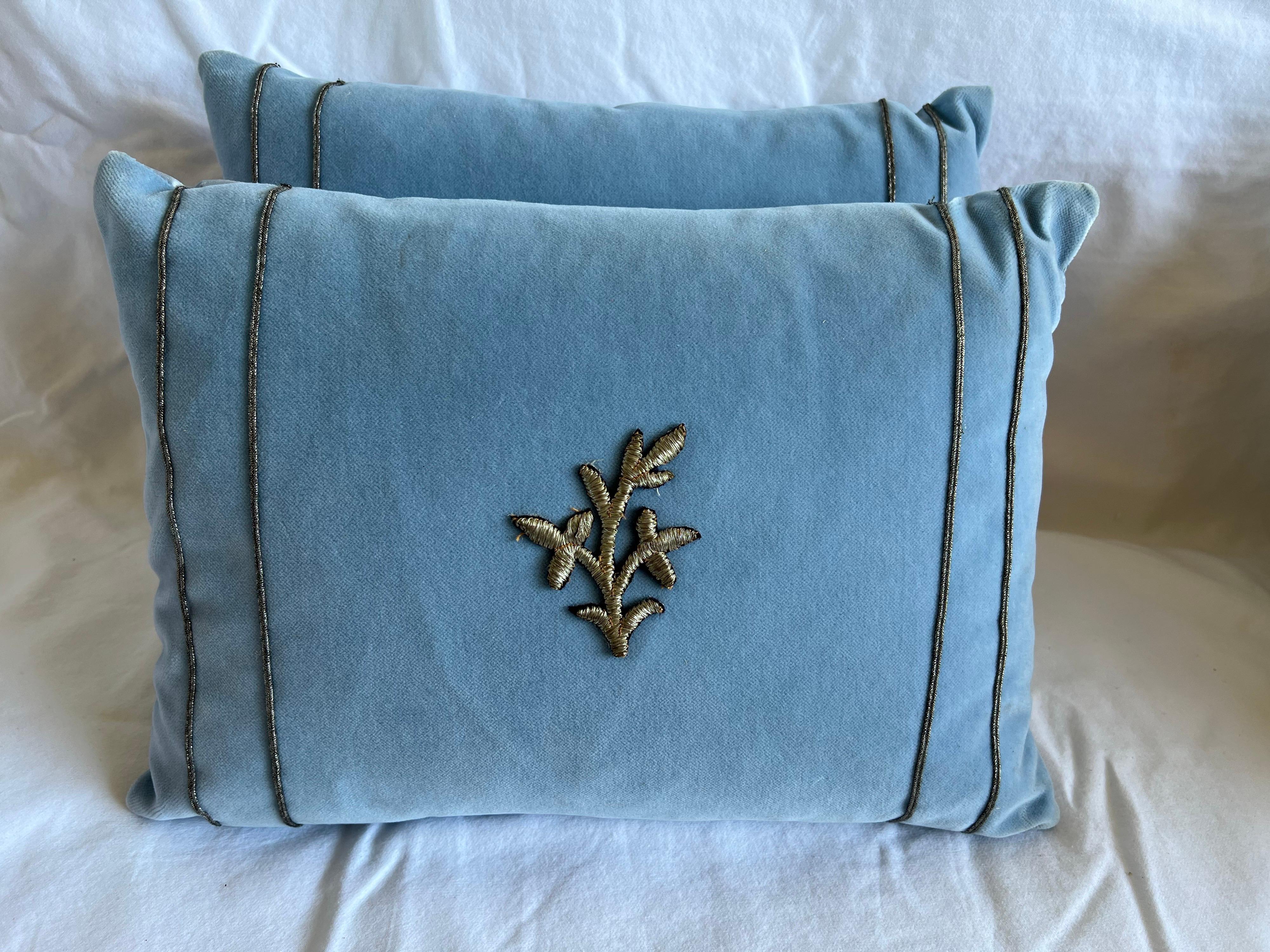 Pair of petite custom applique pillows made with 19th century Italian silver metallic flowers sewn on the fronts of blue velvet pillows. The pillows are also detailed with silver metallic trim at both sides. Down inserts, zipper closures.