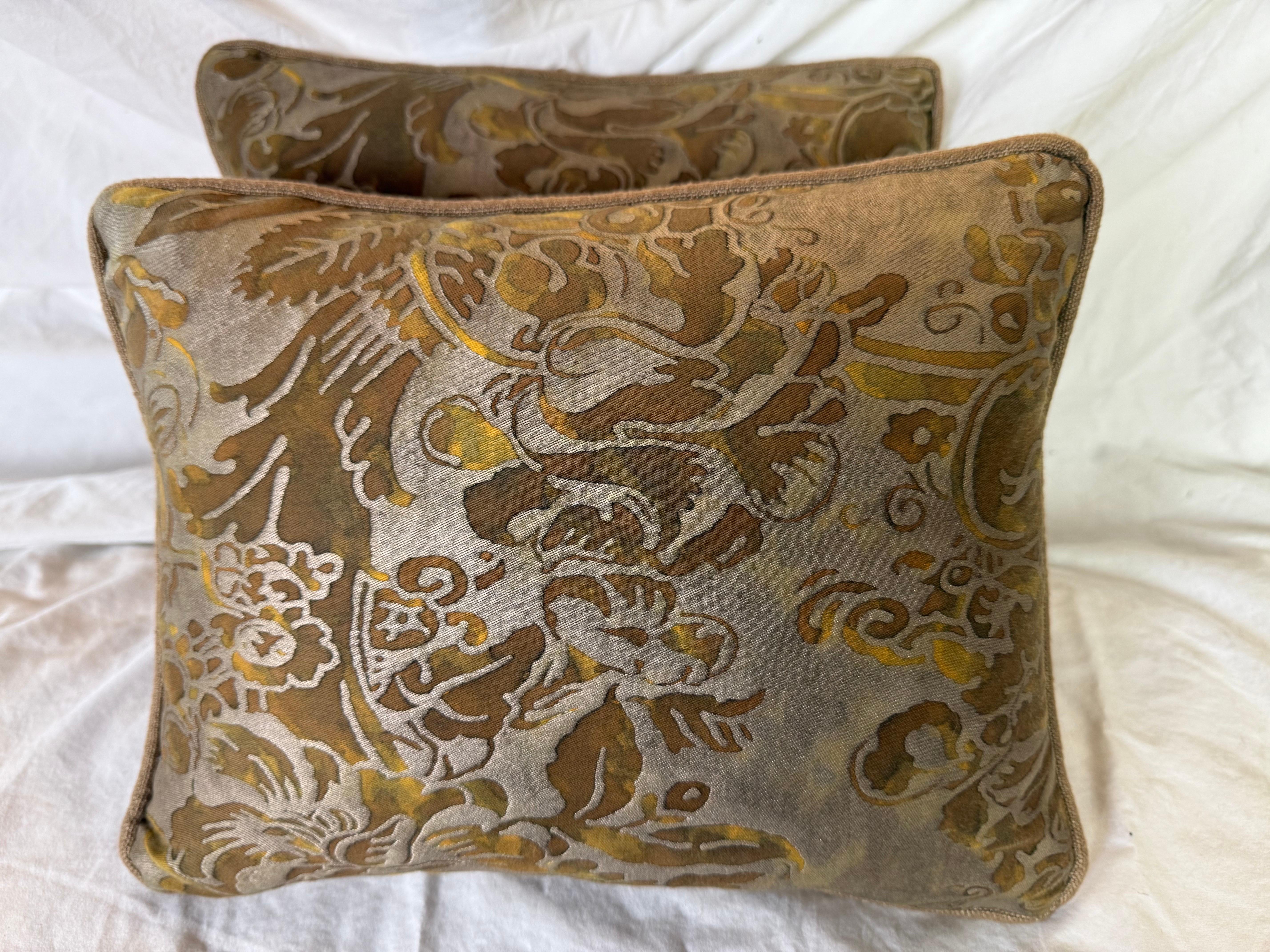 Cette élégante paire de coussins est fabriquée à partir du luxueux textile Fortuny et présente un motif floral et feuillu richement étagé dans des tons chauds de bronze, d'or et de taupe. Le devant en coton décoré au pochoir met en valeur la