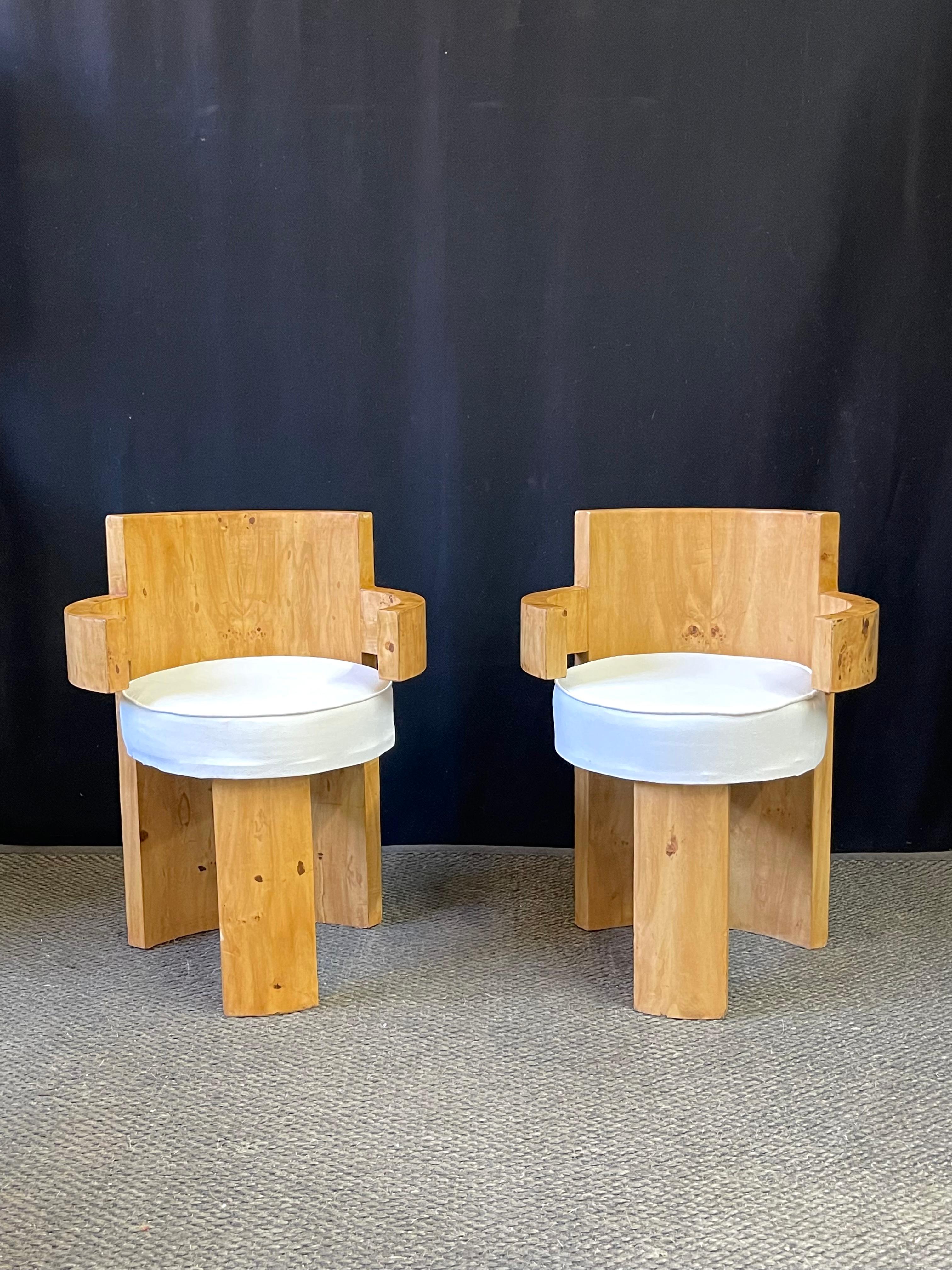 Pair of petite French Postmodern accent chairs, each having arms in a barrel shape circling a white vinyl cushion seat. The frames are veneered in maple with one concave post as the chair's backrest and terminating into the rear foot.
The