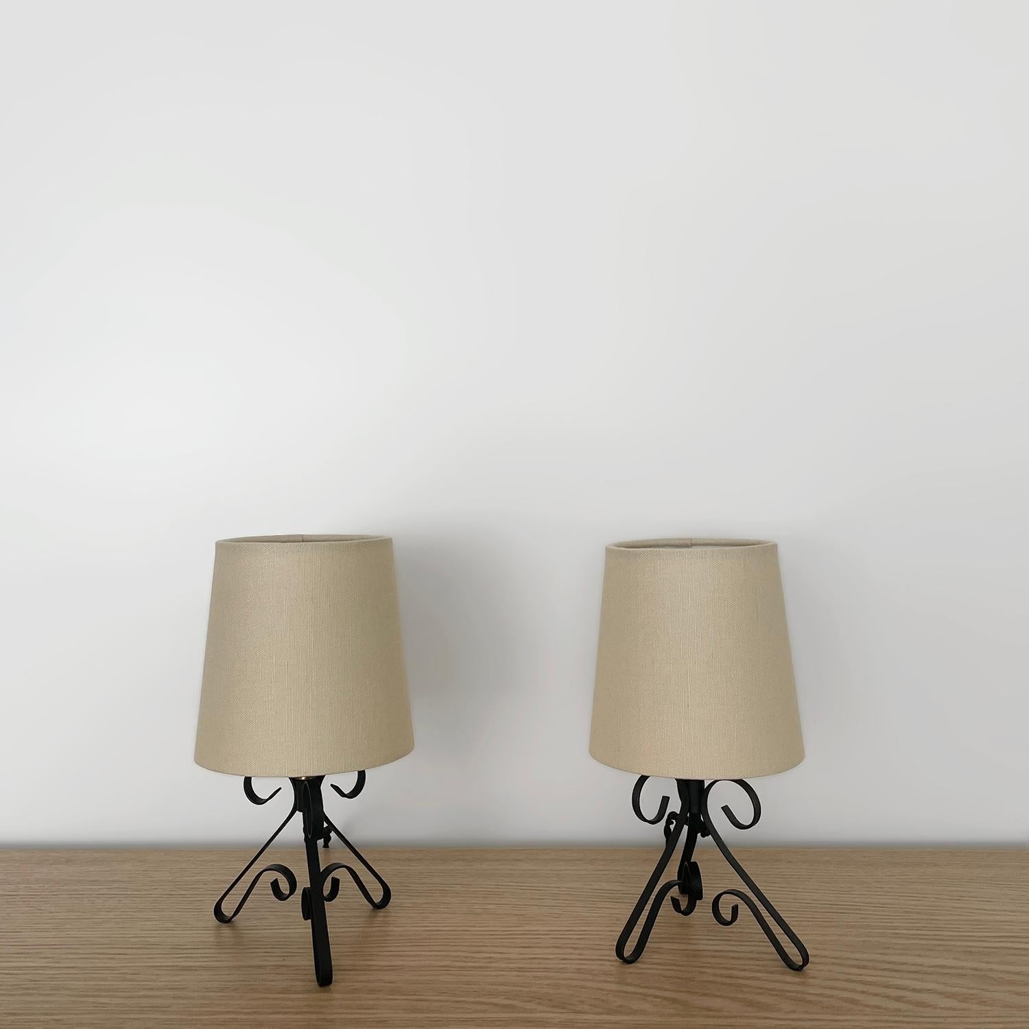 Pair of petite french iron table lamps  
France, mid century 
Delicate and darling are two words that come to mind
Shapely sculpted iron is the center piece with three graceful tripod legs  and swirl details 
Newly rewired
Single socket candelabra