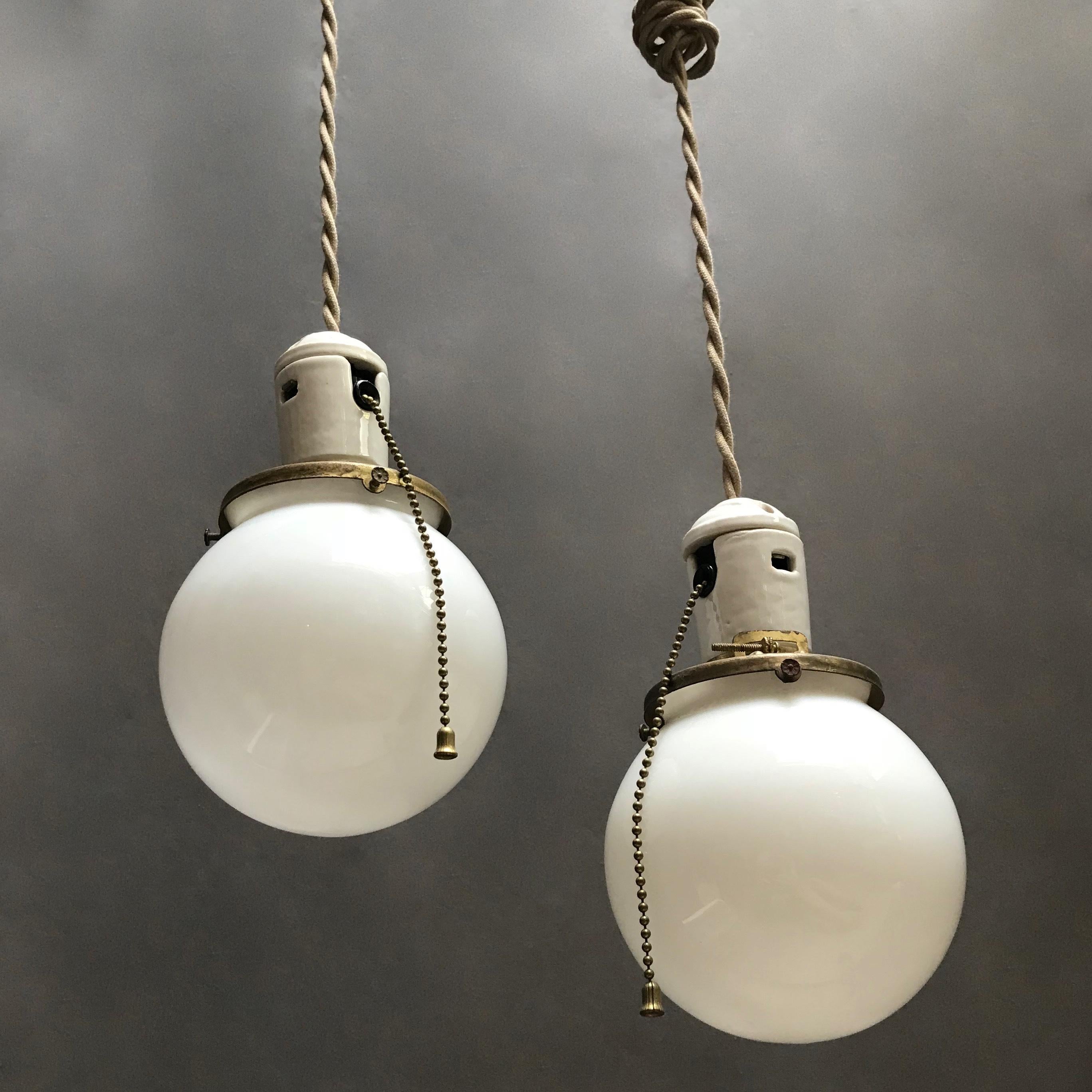 Pair of Petite Industrial Milk Glass and Porcelain Globe Pendant Lights In Good Condition In Brooklyn, NY