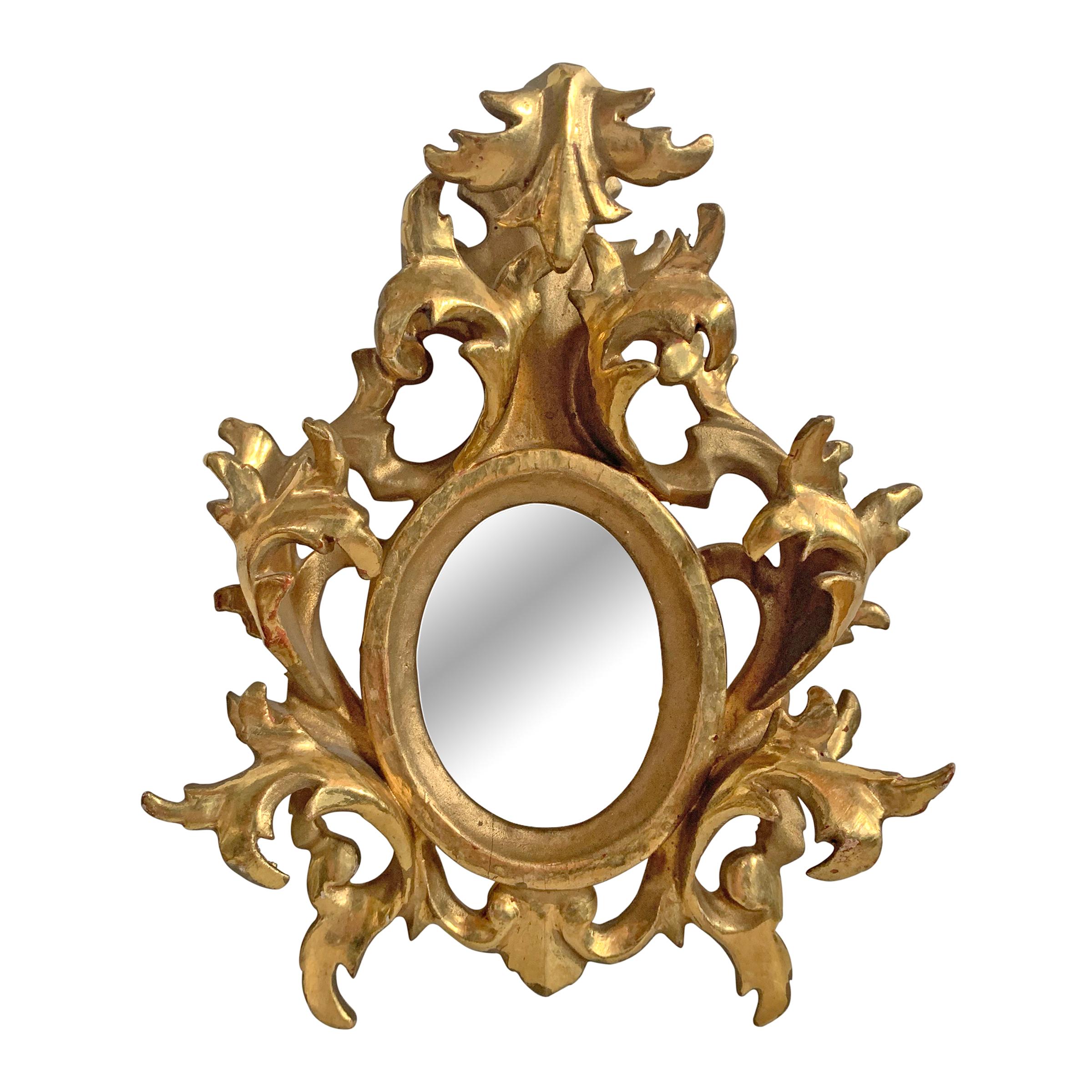 A lovely pair of petite scale Italian gilt framed mirrors with Baroque-style acanthus leaves in high relief.

Mirror size is 2 in. W x 2.75 in. H.