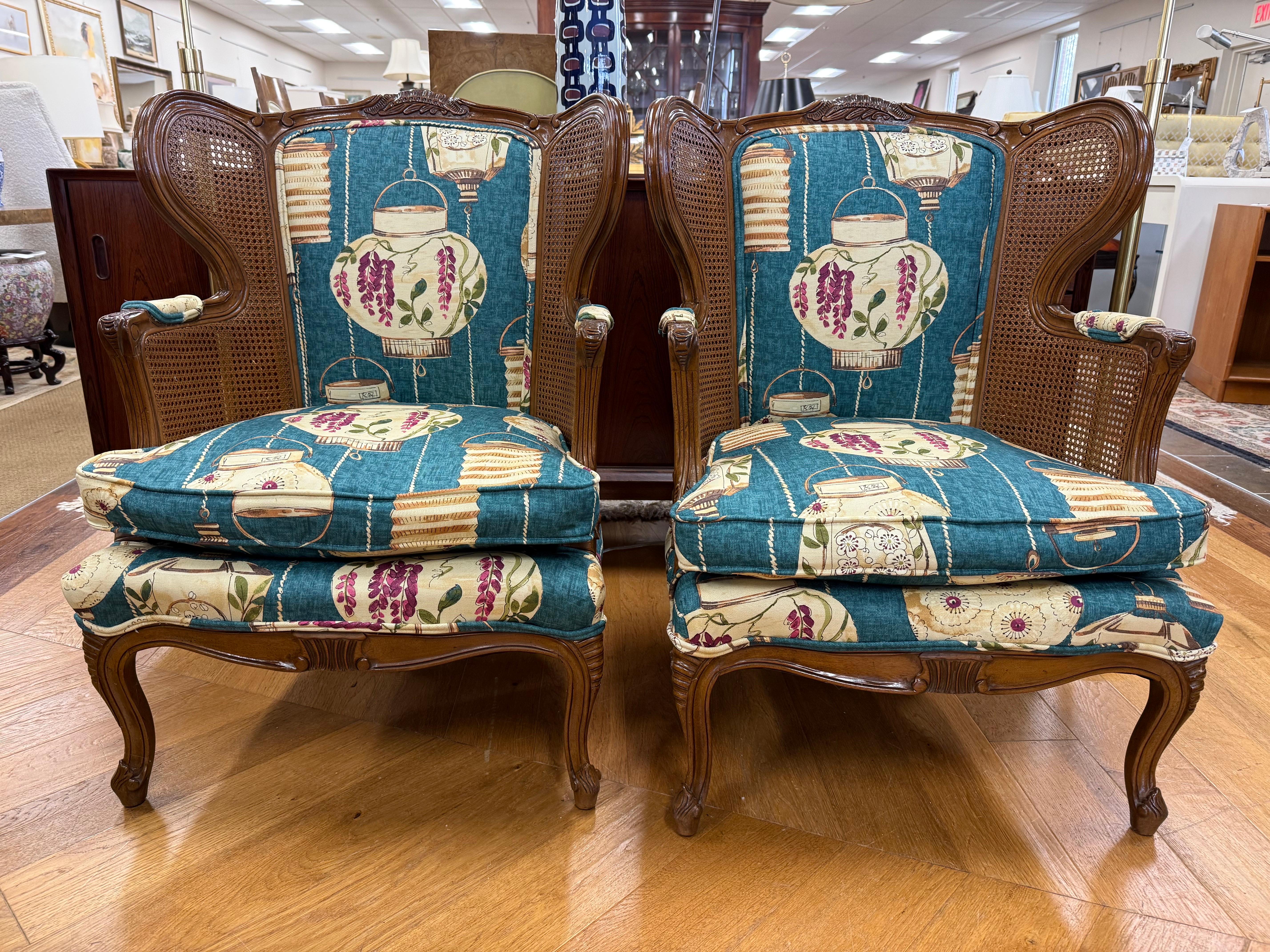Coppia di sedie wingback in noce intagliato d'epoca rivestite di recente con un ricco e lussuoso tessuto Chinoiserie sul davanti e un nuovo tessuto floreale coordinato sul retro. Le rare 