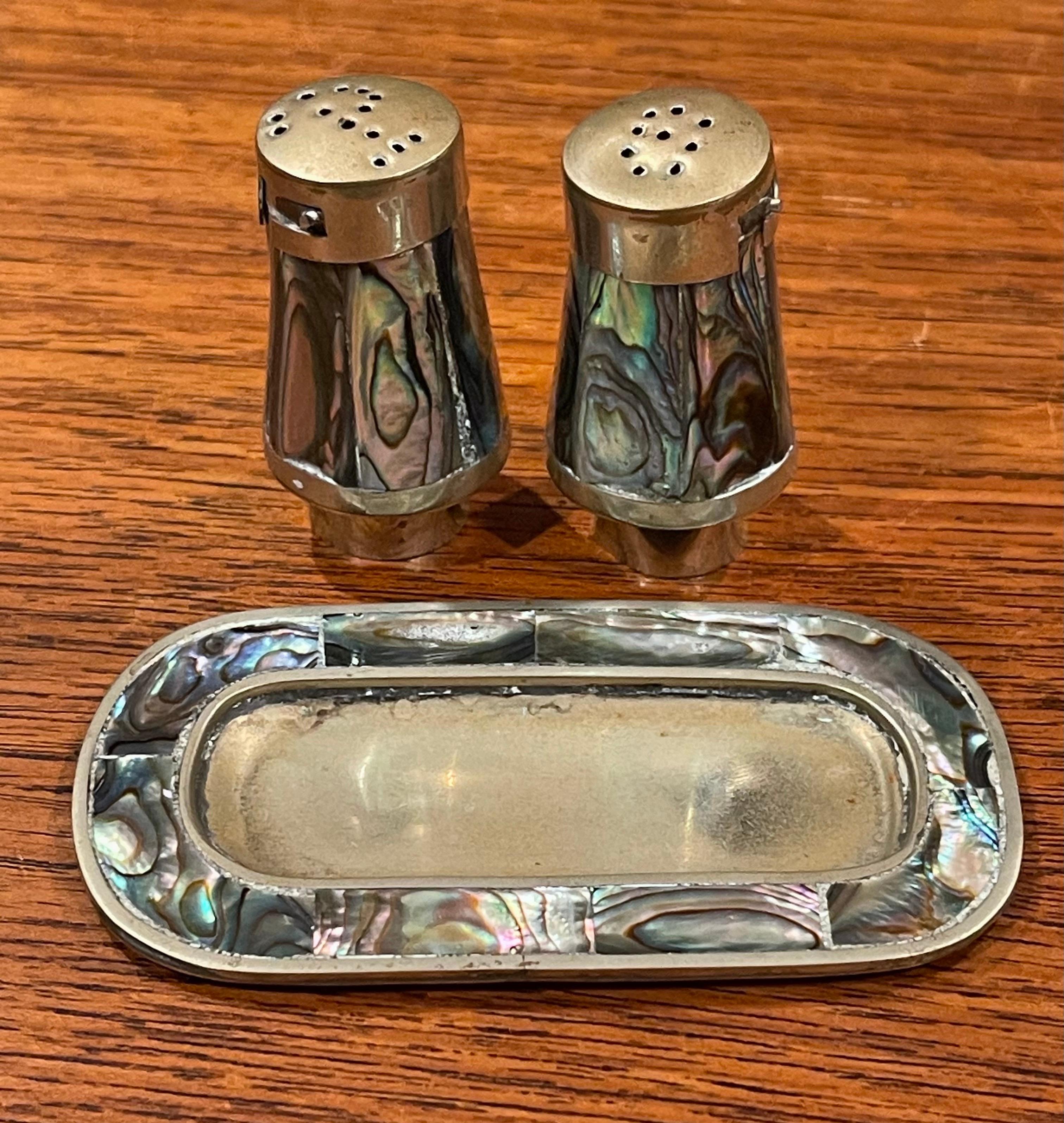 Pair of petite Mexican brass & alpaca salt and pepper shakers, circa 1970s. The set is in good vintage condition with removable lids; the tray measures 3.5