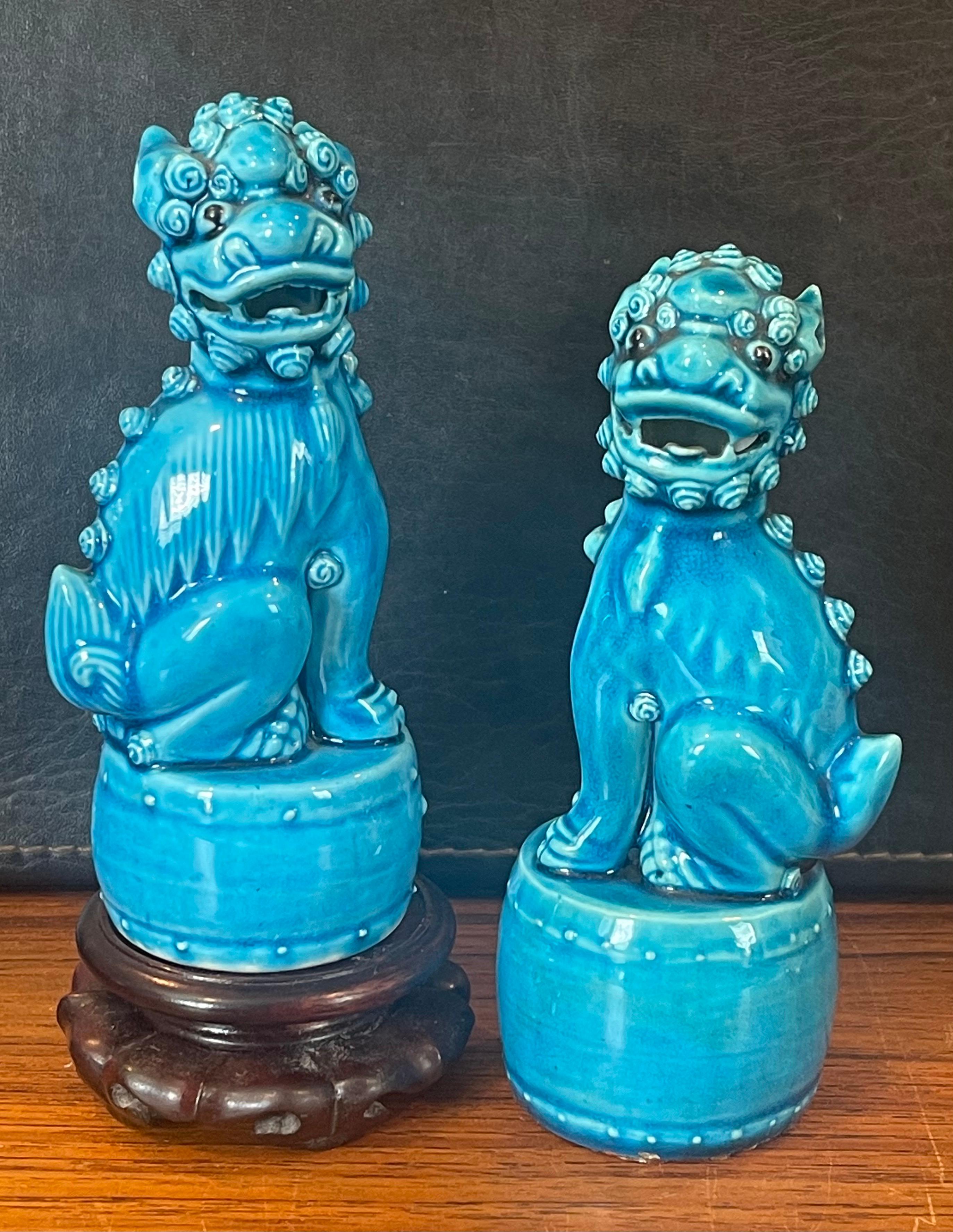 Excellent pair of petite mid-century turquoise blue ceramic foo dog sculptures, circa 1960s. These symbolic guardians present a beautiful turquoise hue and are in very good vintage condition with no chips or cracks. The dogs measure 5.5