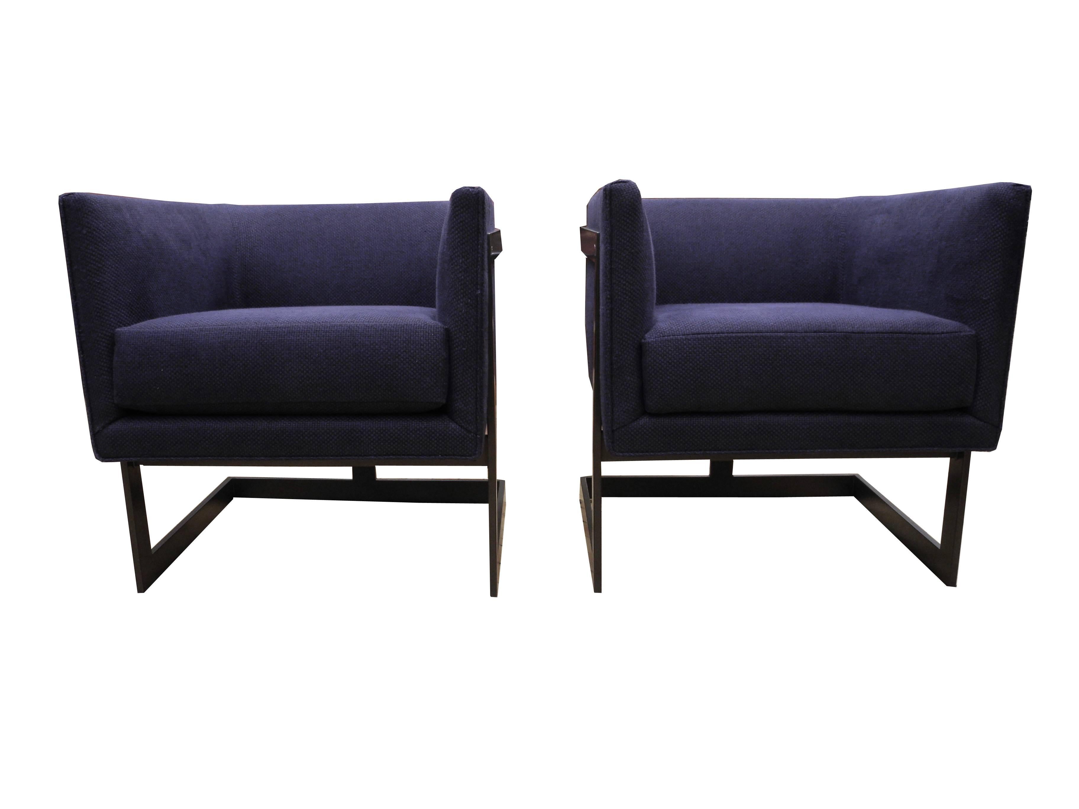 These boxy armchairs have a woven navy blue fabric and a bronze finish frame.
