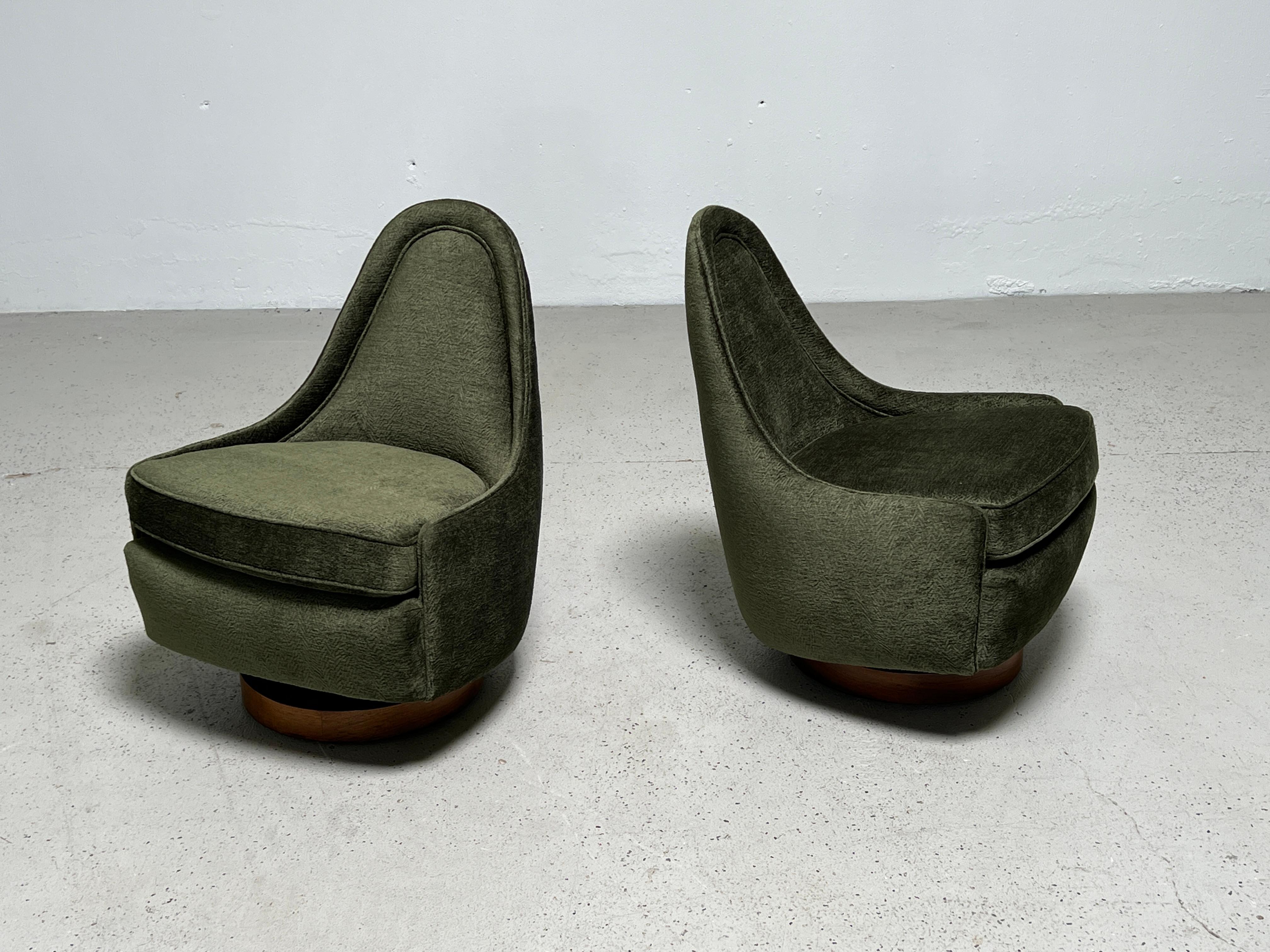 A pair of small-scale rocking swivel chairs on walnut bases. Designed by Milo Baughman for Thayer Coggin.