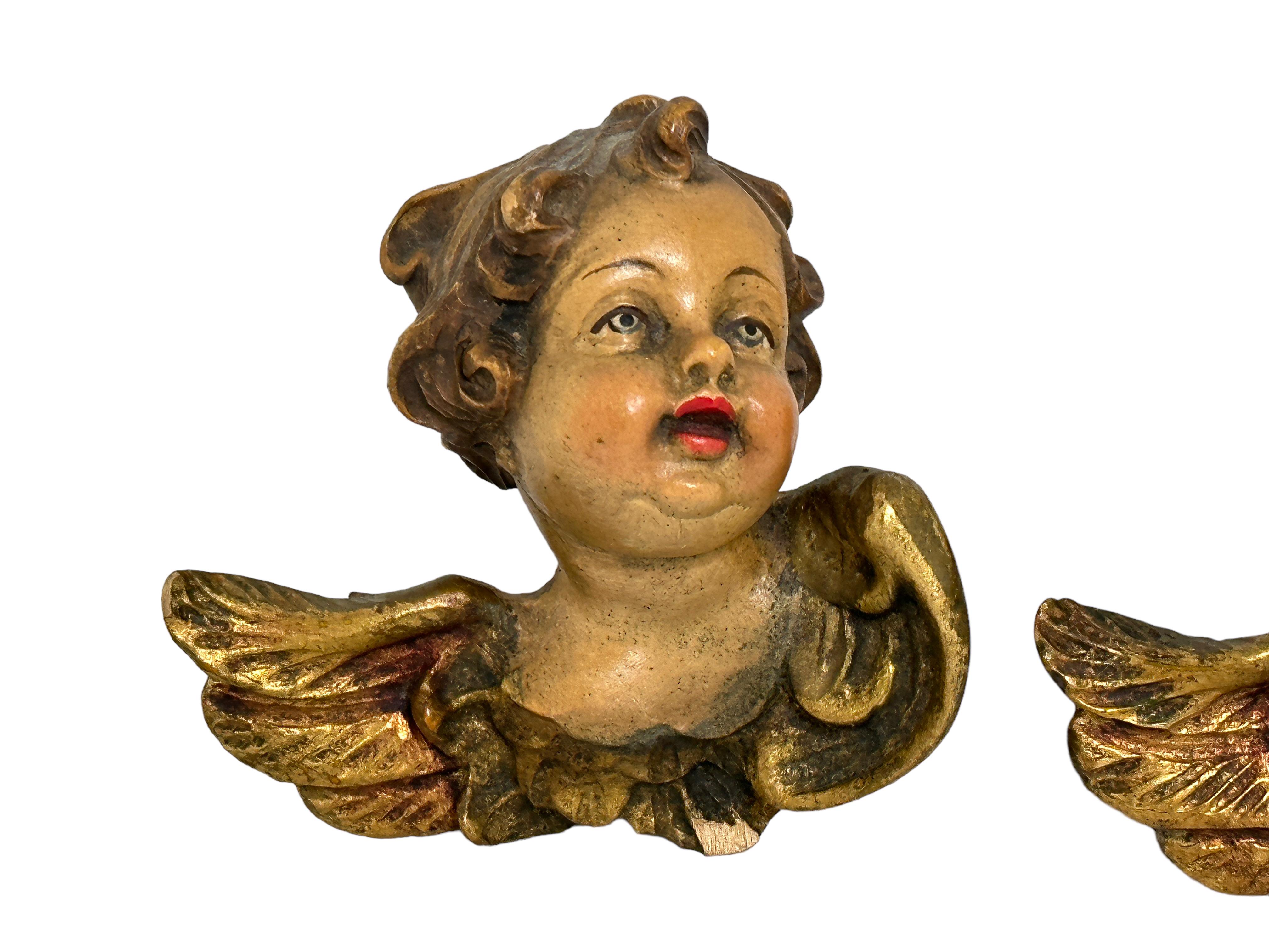 A pair beautiful petite hand carved cherub angel Heads, found at an estate sale in Germany. Made by a woodcarver in the Tyrollean Area in Austria, this area is well-known for their wood carvings. The size given in the dimensions section refers to