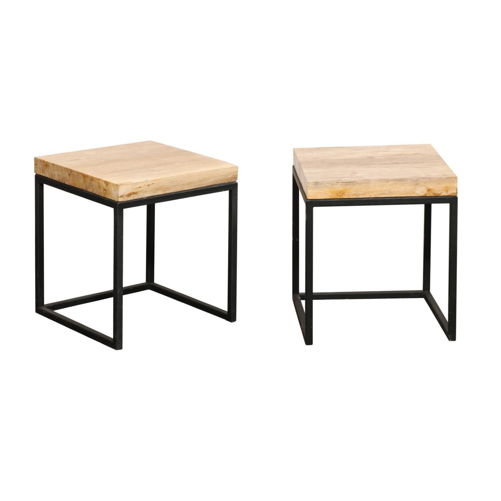 A pair of modern style custom petrified wood top side tables. This pair of tables each feature a square-shaped petrified wood top, in beautiful warm beige and brown tones. The tops are supported by a custom metal base, which is black in color, with