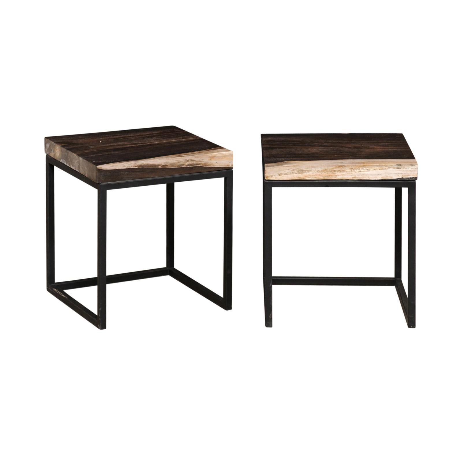 A pair of modern style custom created petrified wood top and iron side tables. This pair of tables each feature a 15.75