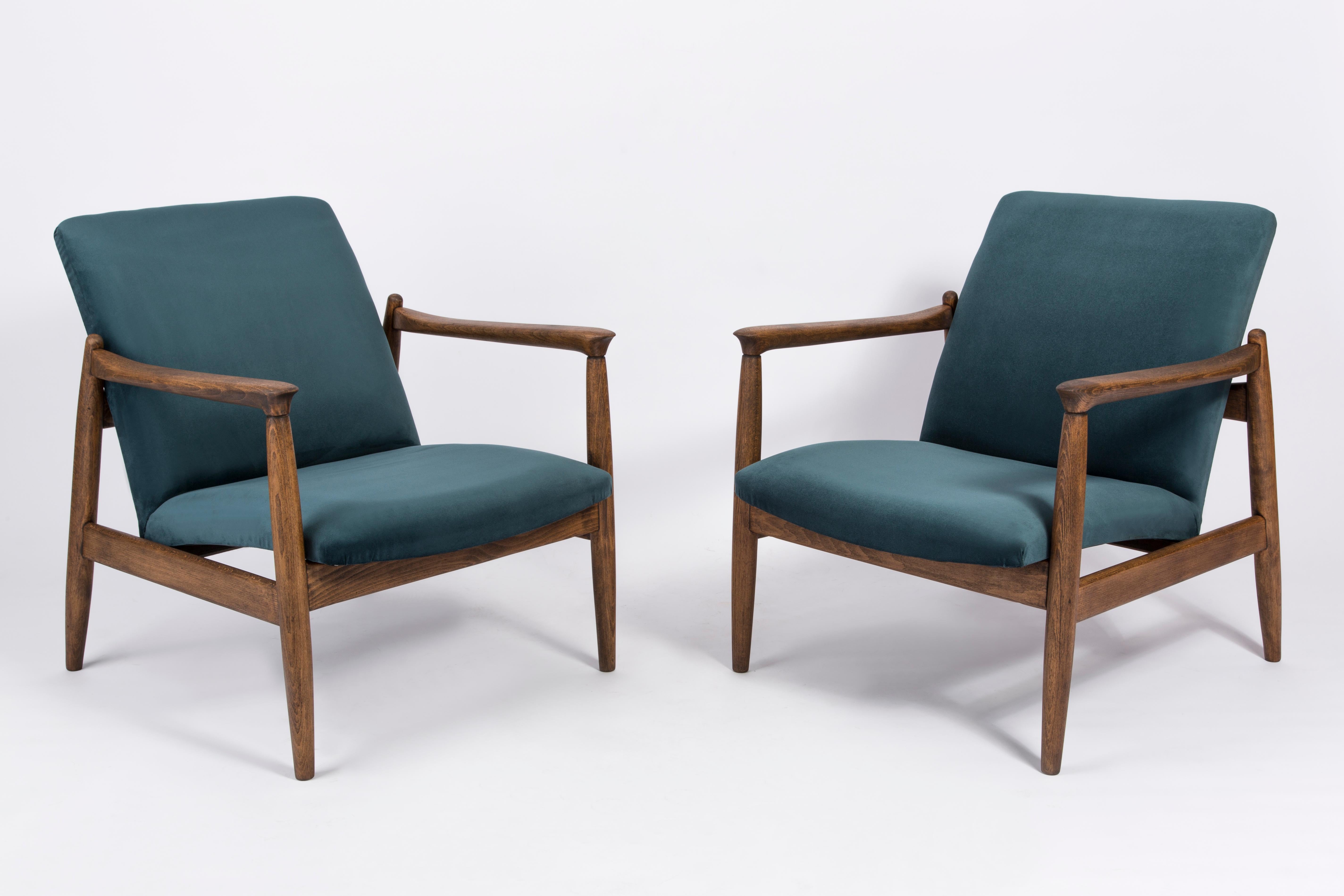 A pair of petrol blue armchairs, designed by Edmund Homa. The armchairs were made in the 1960s in the Gosciecinska Furniture Factory. They are made from solid beechwood. The GFM type armchair is regarded one of the best Polish armchair design from