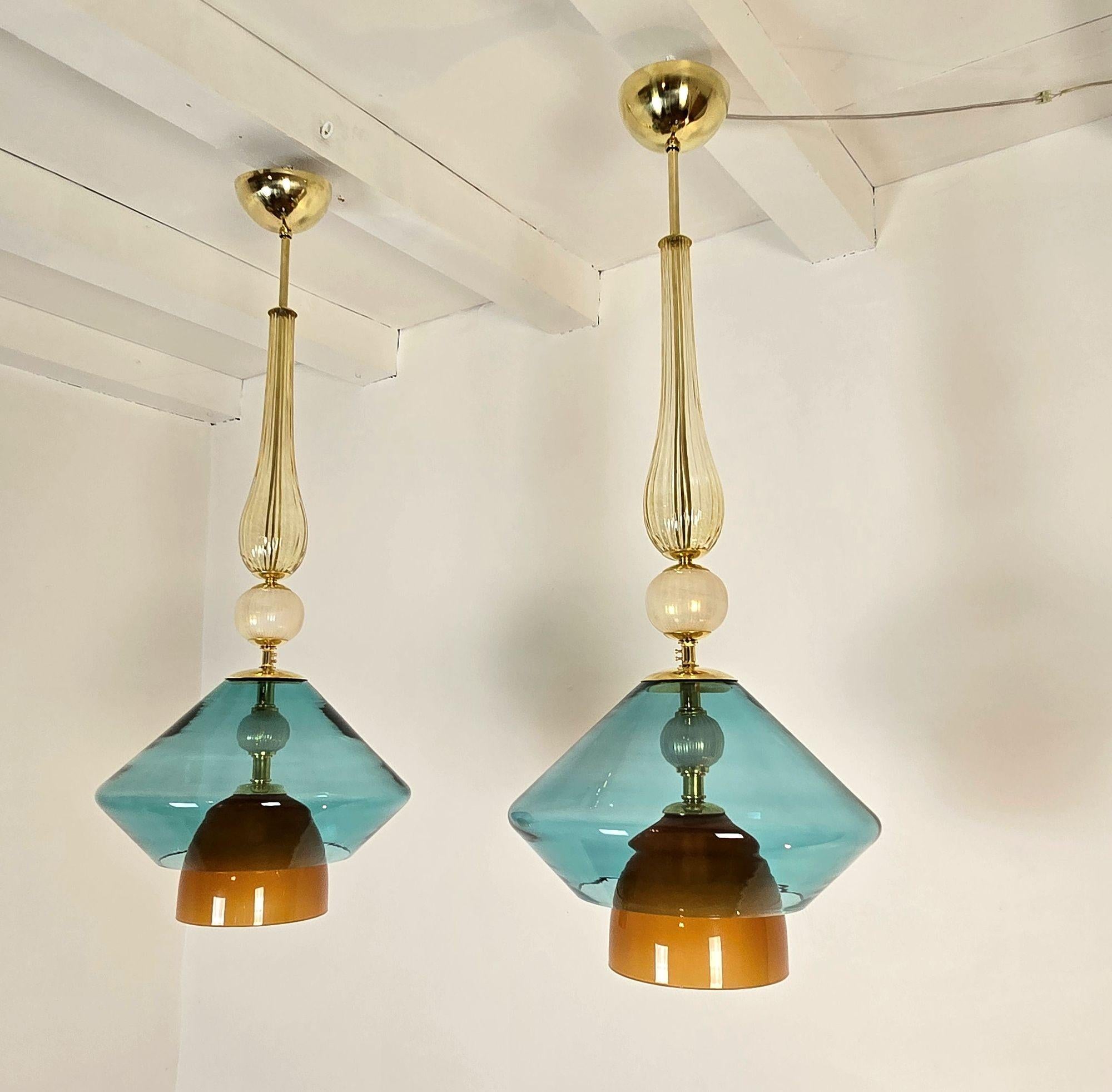 Coppia di lampade a sospensione in vetro di Murano del Mid-Century Modern, Italia, circa anni 2000.
I lampadari italiani sono realizzati con elementi in oro, terracotta e vetro di Murano blu petrolio.
L'asta centrale e le parti metalliche sono in
