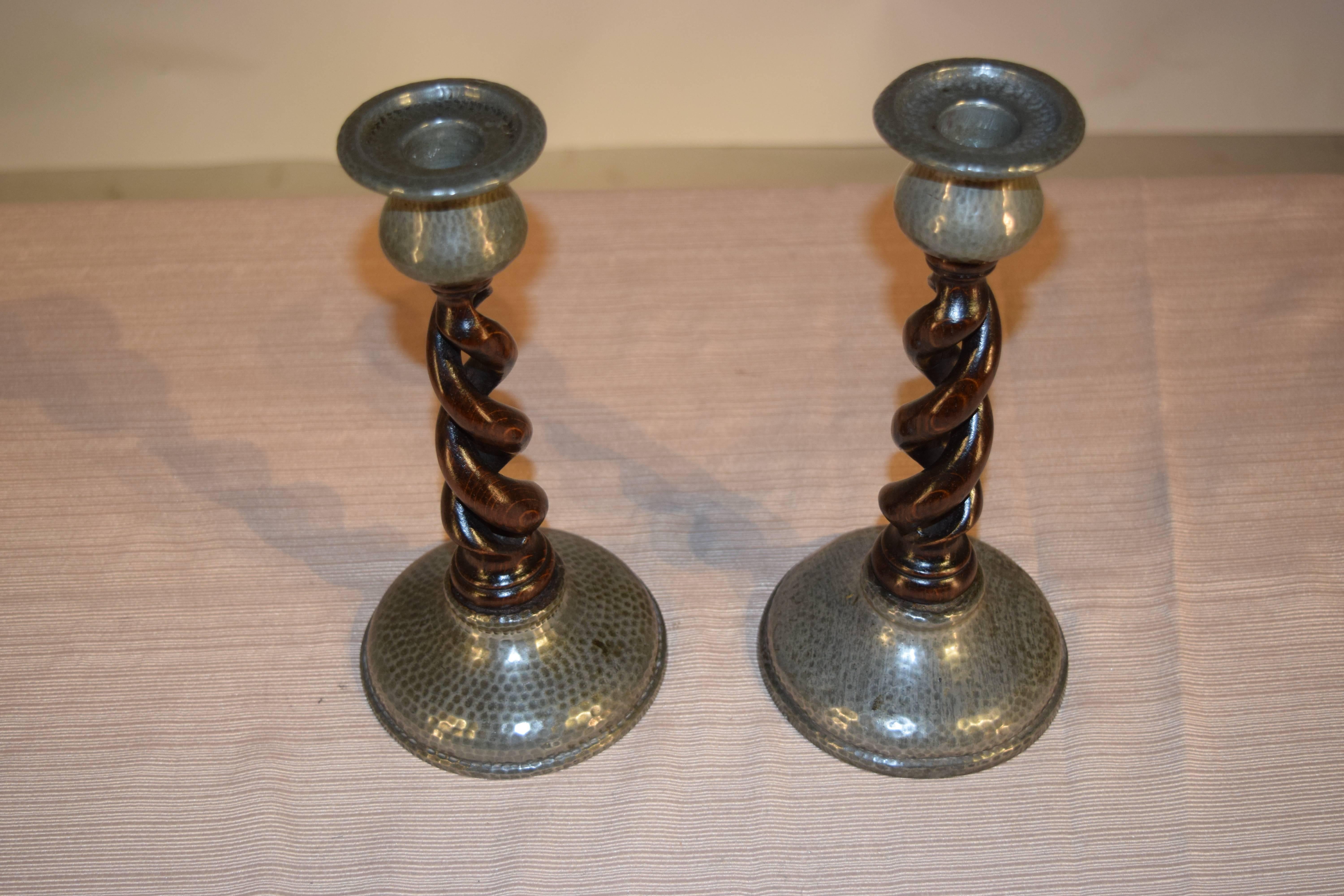 Pair of English made oak open barley twist candlesticks with hand-hammered pewter candle cups and bases.
 