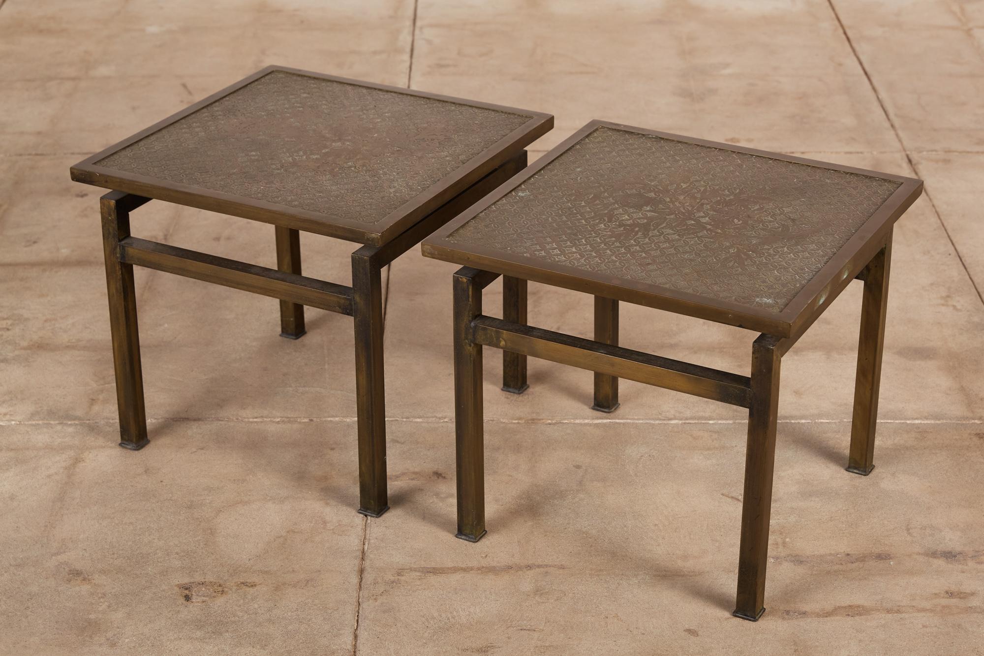 A pair of highly collectible side tables by Philip and Kelvin Laverne. The square shaped tables features their signature acid etched motif pattern on the tabletop that is floated above four four square patinated bronze legs with two horizontal
