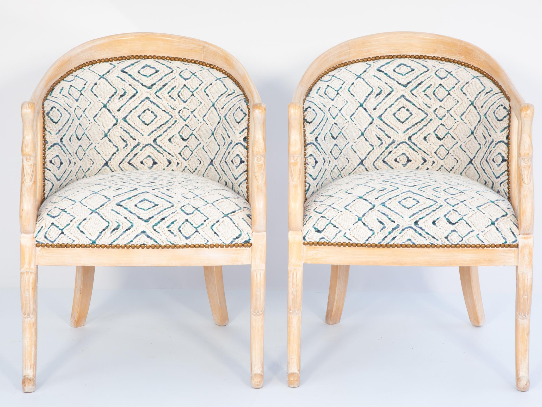 Pair of vintage tub chairs, having a pickled beechwood finish, each barrel-form, arched crestrail continuing into downswept, terminals carved as swan necks ending in scrolls, raised on rounded sabre legs; newly upholstered with nail heads. 

Please