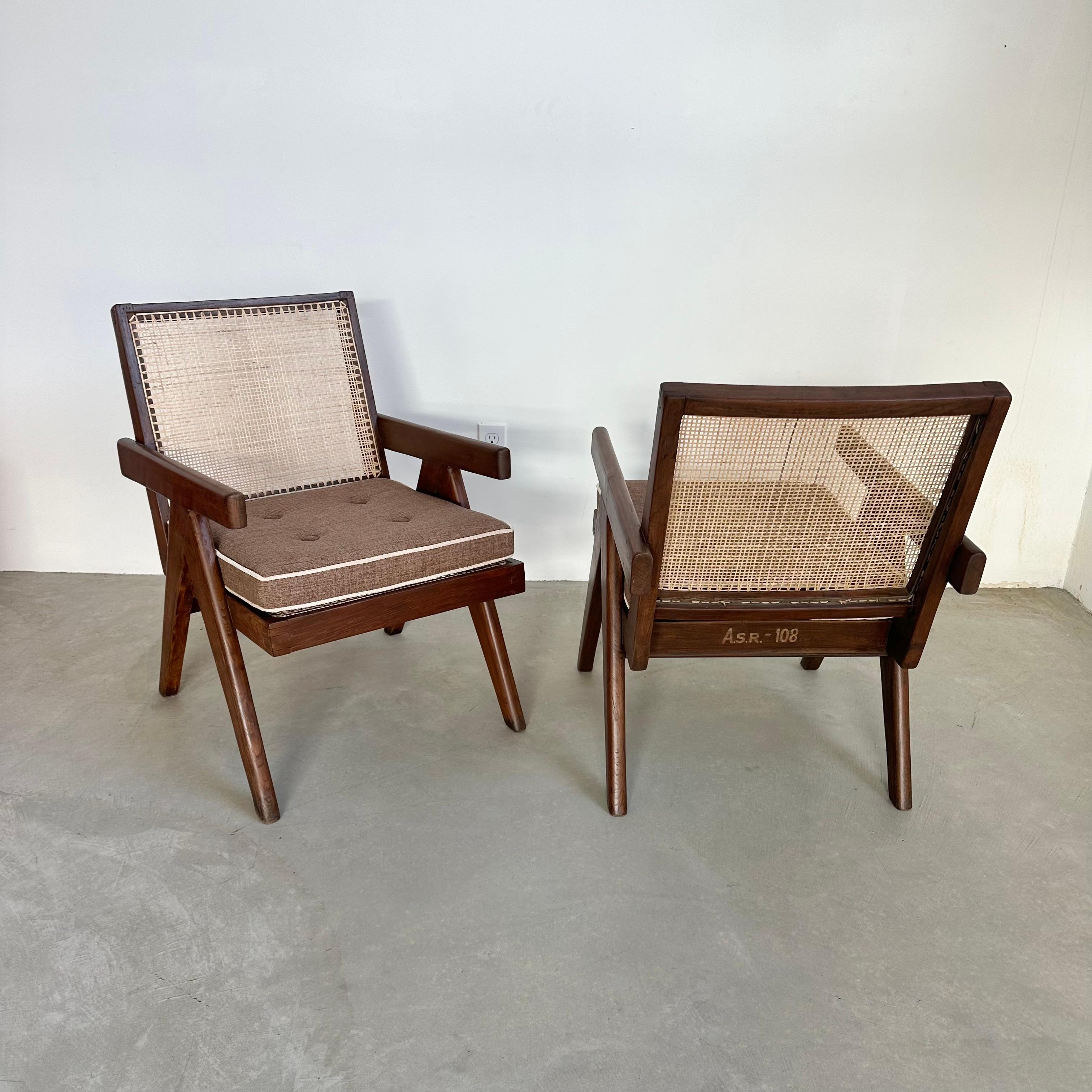 Una coppia di sedie Easy Chair disegnate da Pierre Jeanneret negli anni Cinquanta. Originariamente creati per la città di Chandigarh, in India, gli intricati disegni di Pierre sono diventati amati in tutto il mondo. Semplici ma eleganti, queste