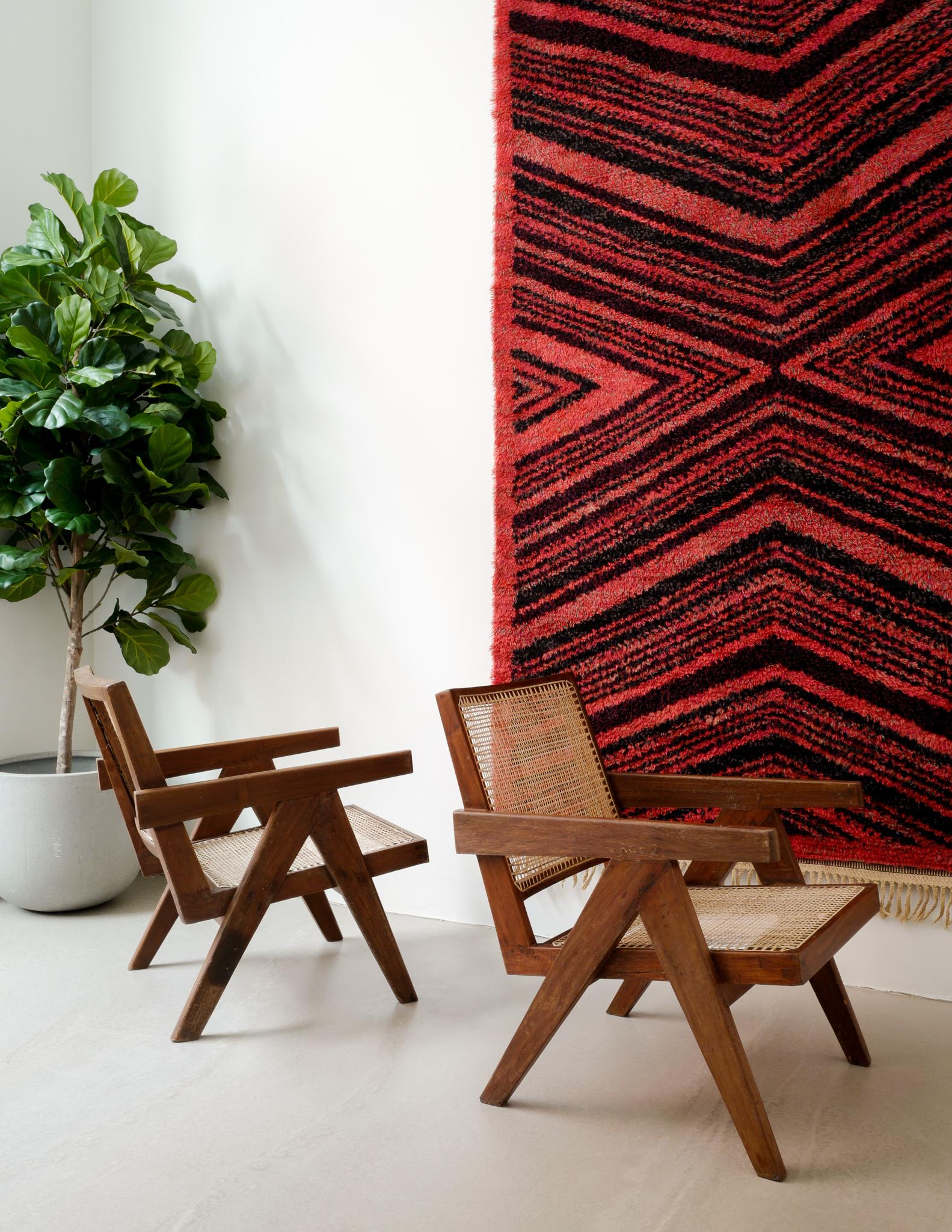 Rare pair of mid-century Pierre Jeanneret easy chair in teak and rattan produced in India for his and Le Corbusier's university project in the 1950s. In good vintage condition with small signs of age and use. Both chairs have matching lettering and