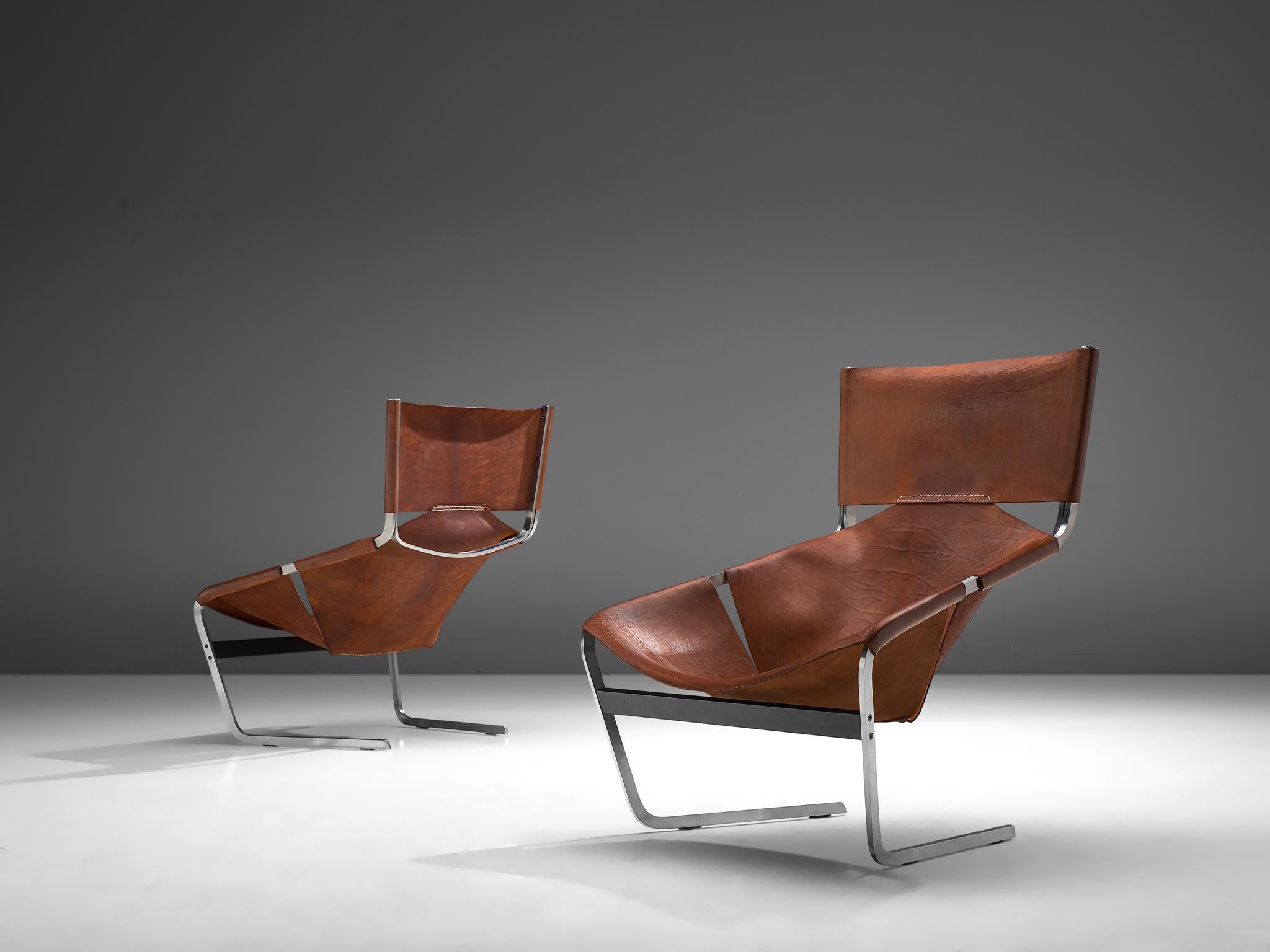 Pierre Paulin for Artifort, pair of F-444 easy chairs, metal and cognac leather, the Netherlands, circa 1962.

Pair of cognac leather F-444 chairs, designed by Pierre Paulin for Artifort in 1962. The chairs show sharp lines and an angled open seat