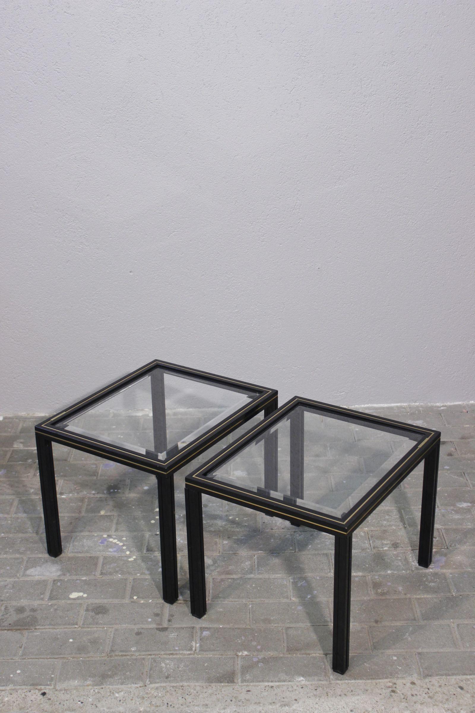 Pareja de mesas auxiliares Pierre Vandel Paris circa 1970, estructura de aluminio lacado en negro, inclusión de banda dorada, cristal biselado original que descansa sobre deslizadores de goma negra.

Todo en buen estado, firma en placa de metal