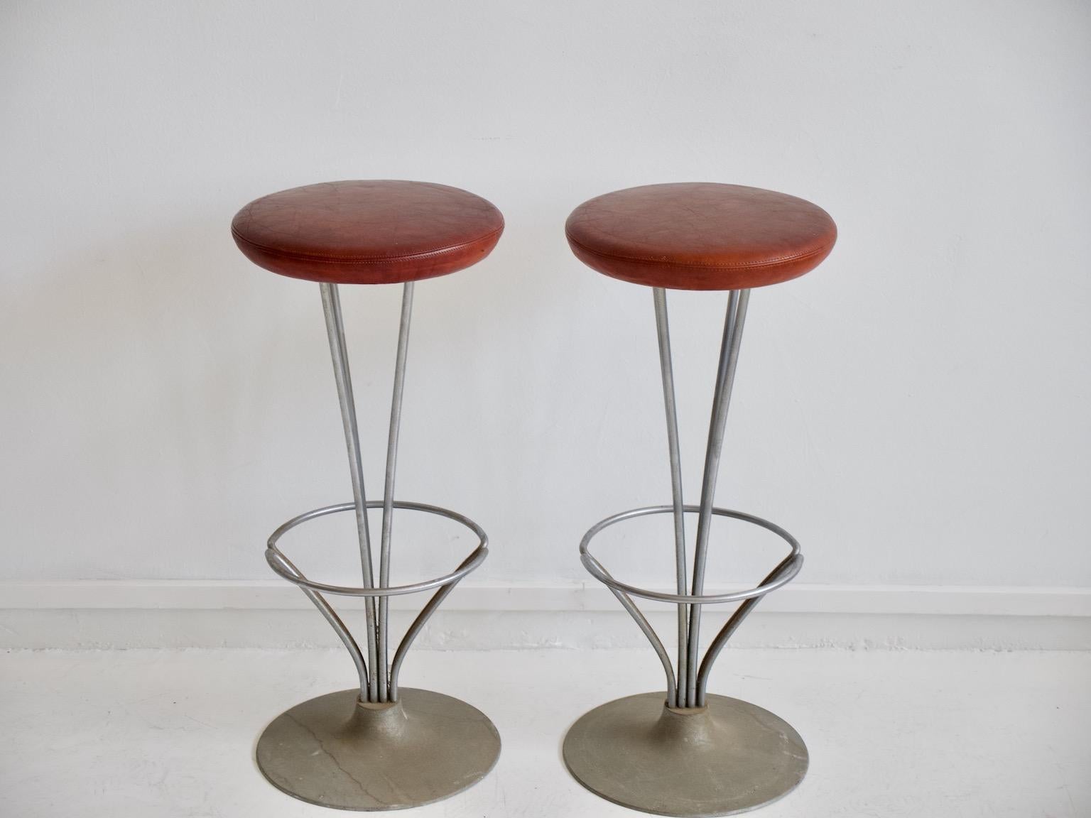 Pair of high bar/kitchen stools with chrome-plated metal frame, mounted on round aluminum foot, seat originally upholstered in cognac-colored leather. Designed in 1961 by Piet Hein. Produced by Fritz Hansen.
Literature: Noritsugu Oda. Danish