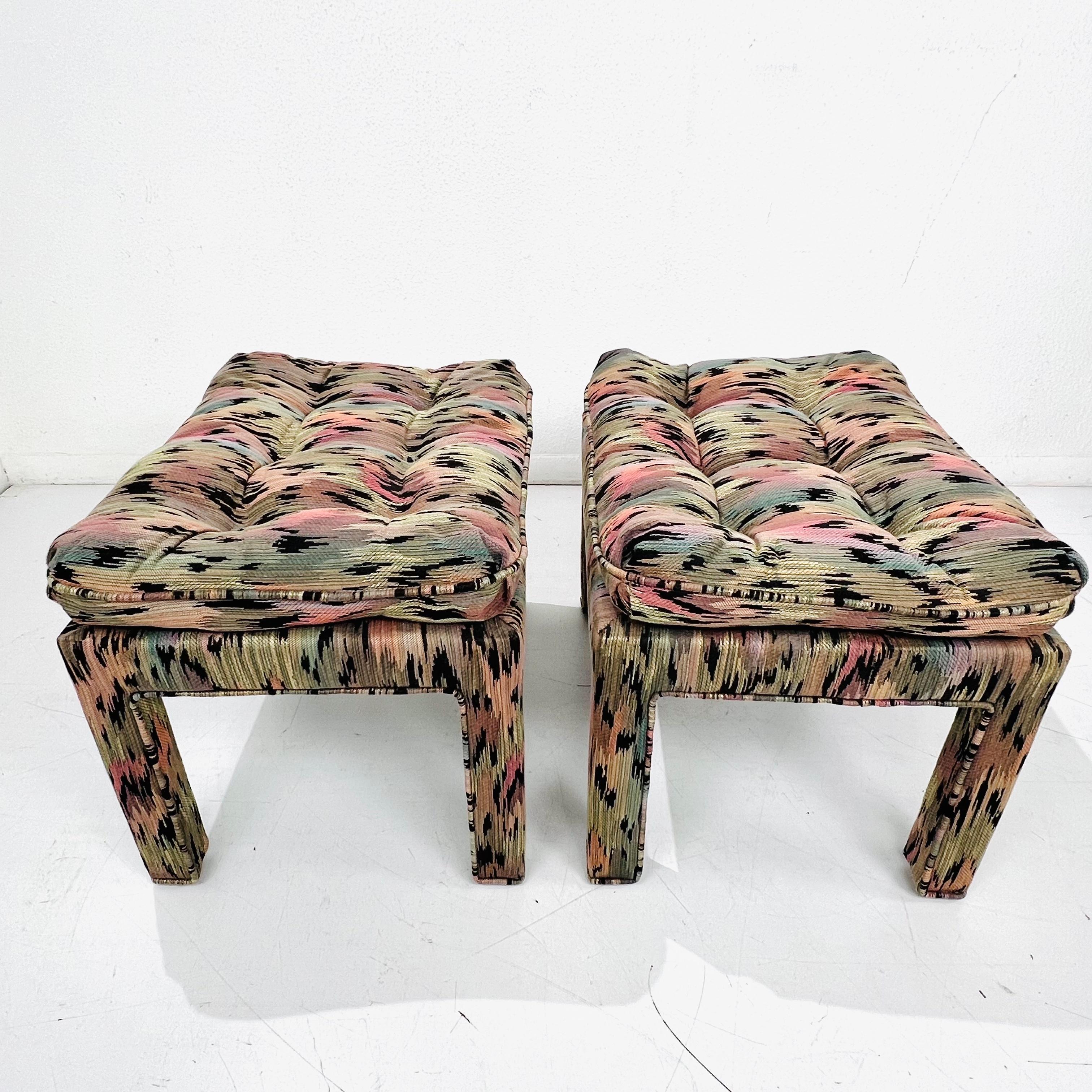 Super sexy pair of 1970s Parsons style ottomans or stools in sultry rainbow leopard with piping detail. Tufted top cushion is complimented with upholstered piped legs. A timeless Silhouette in a fierce fabric! Very good condition, no stains or tears