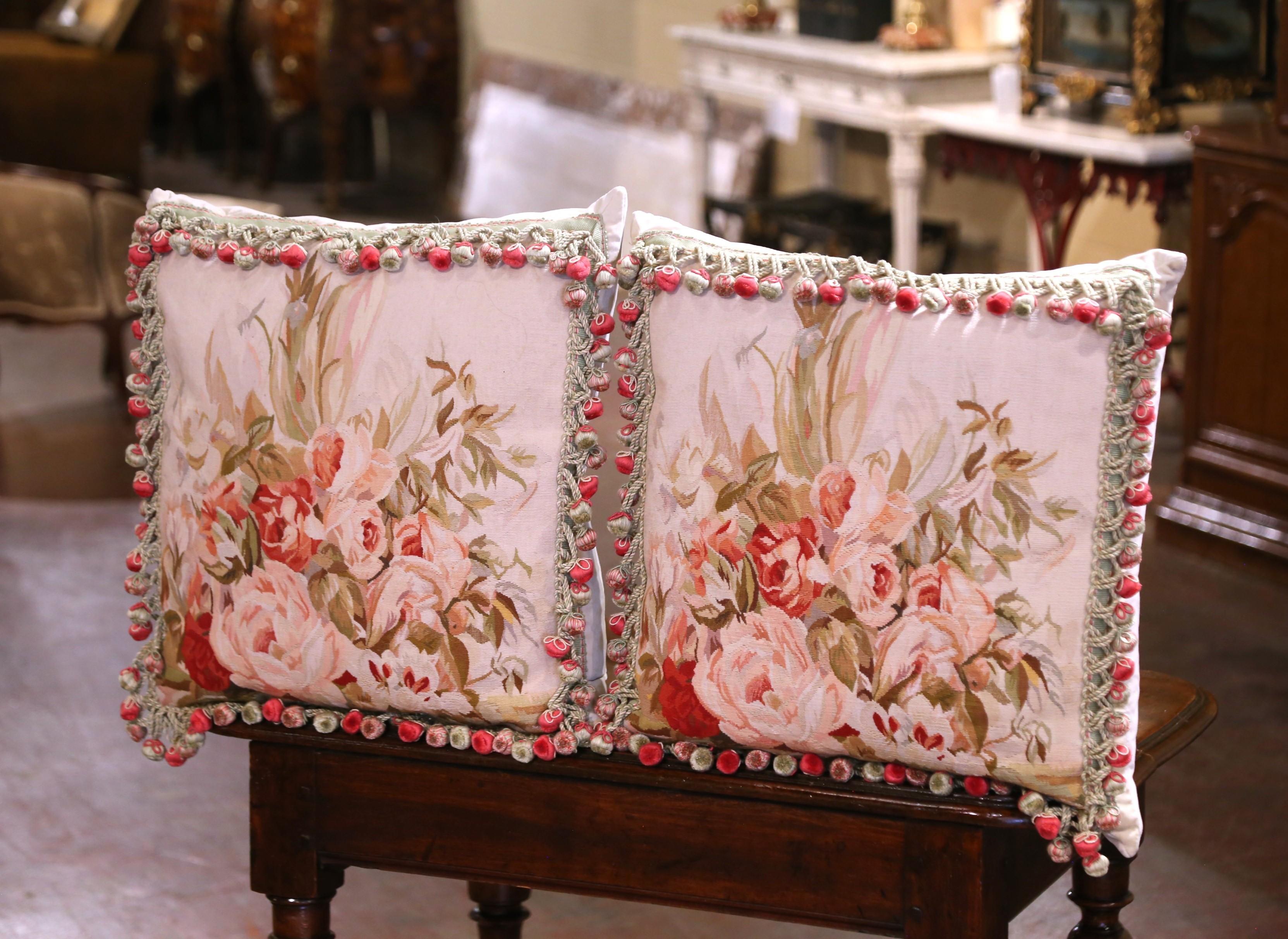 Aggiungi un tocco romantico ai tuoi interni con questa elegante coppia di cuscini con arazzo antico. Realizzato con arazzi del XIX secolo provenienti da Aubusson, in Francia, ogni grande cuscino è realizzato a mano con rifiniture e nappe in omaggio