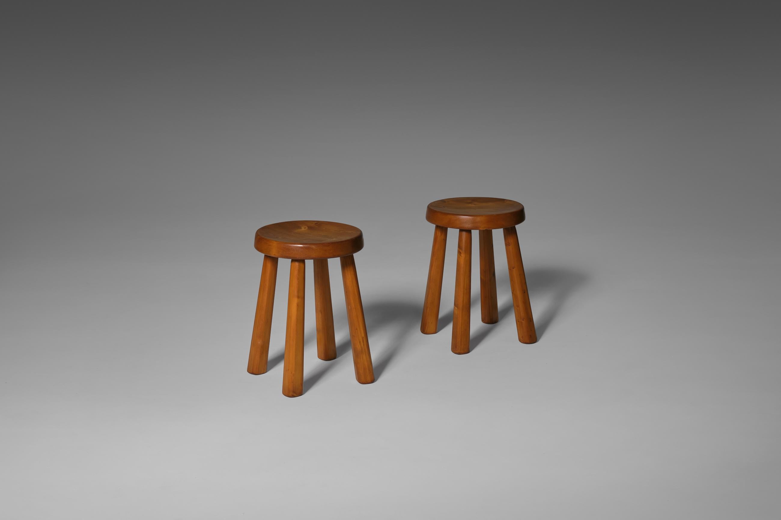 Pair of four legged stools coming from the Les Arcs Ski resort, ca 1970. Often attributed to Charlotte Perriand. Modest design with beautiful details such as the curved seats and stubborn bulky legs. The solid pine stools shows an incredible patina.