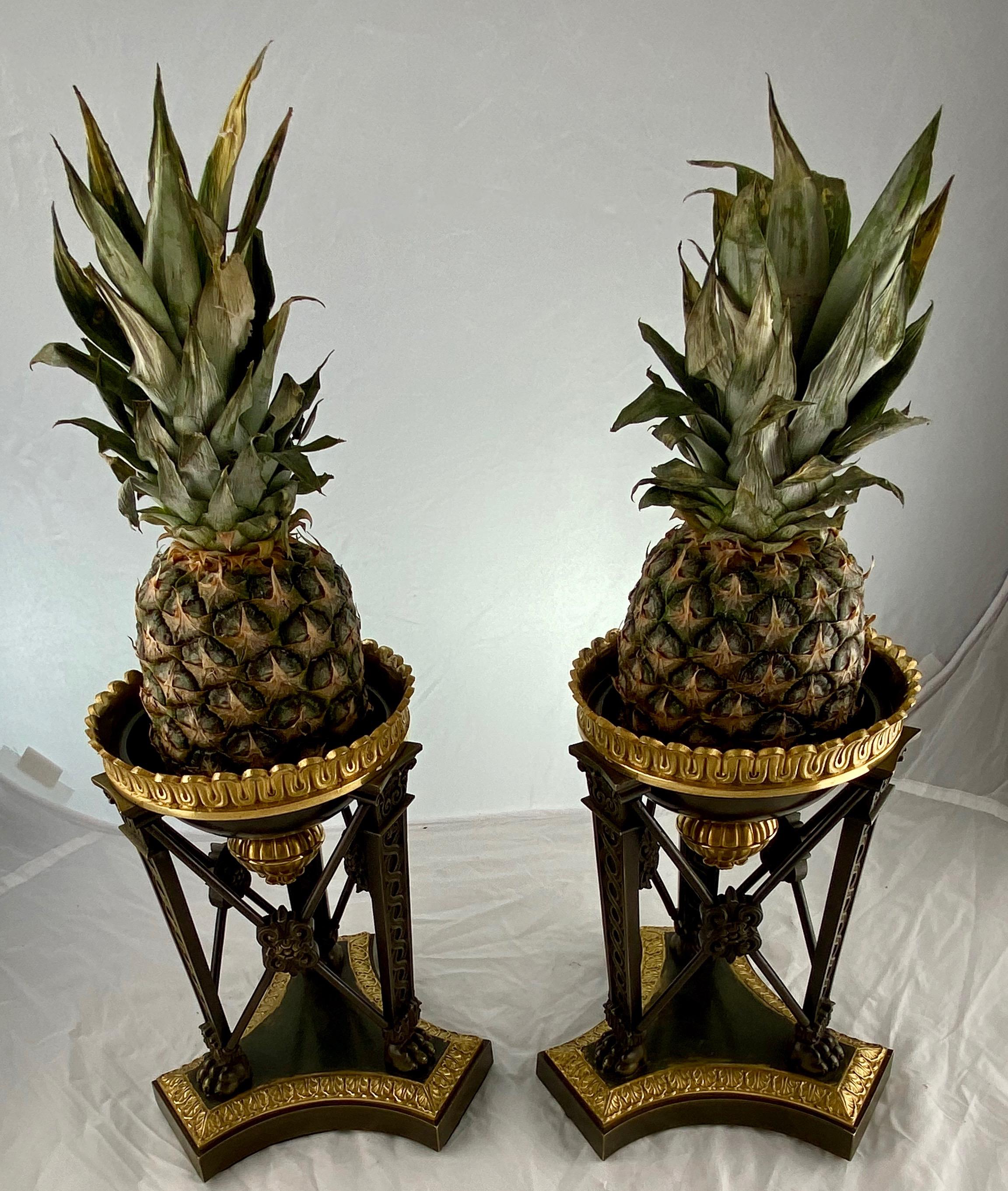 A splendid pair of pineapple holders, they just look great. At a table or in an entrance or anywhere you want people to feel welcome. Dark-patinated and gilt bronze made around 1820. They can also be used without pineapples and then have more of a