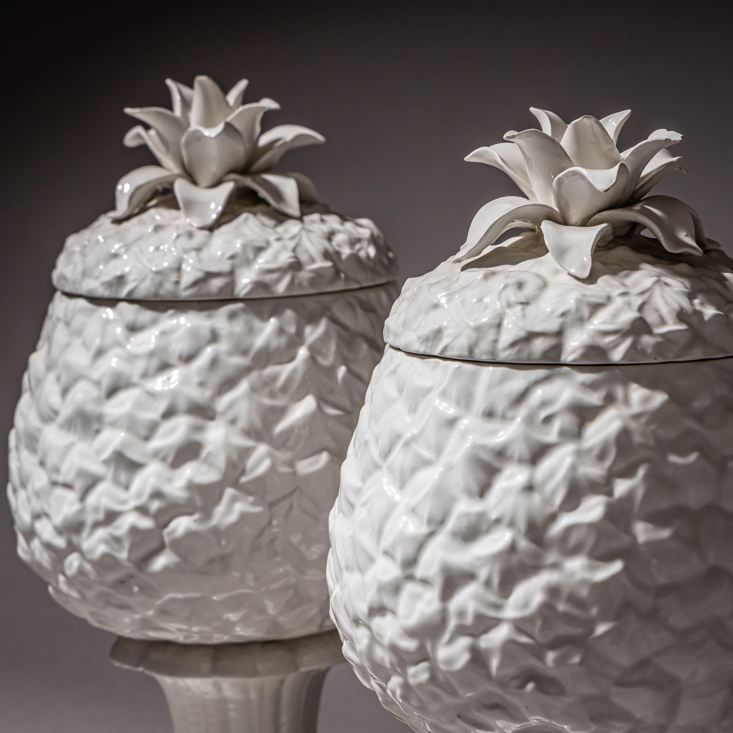 Pair of lidded vases in white-glazed porcelain on a circular base, designed in the shape of stylized pineapples. Illegibly stamped on the underside.