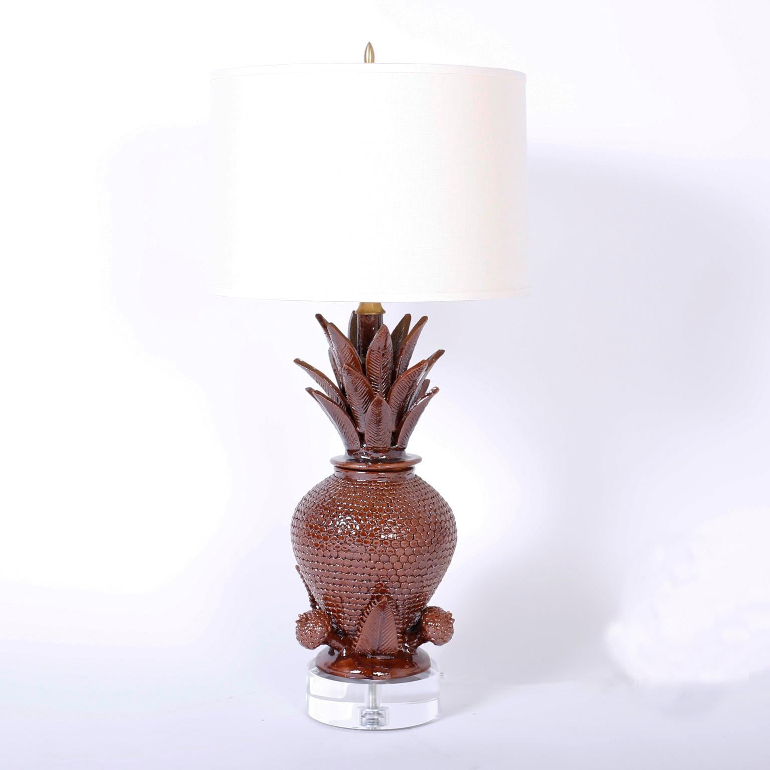 Impressive pair of brown glazed terra cotta table lamps with an ingenious display of pottery prowess in the form of these stylized pineapples, presented on thick Lucite bases.