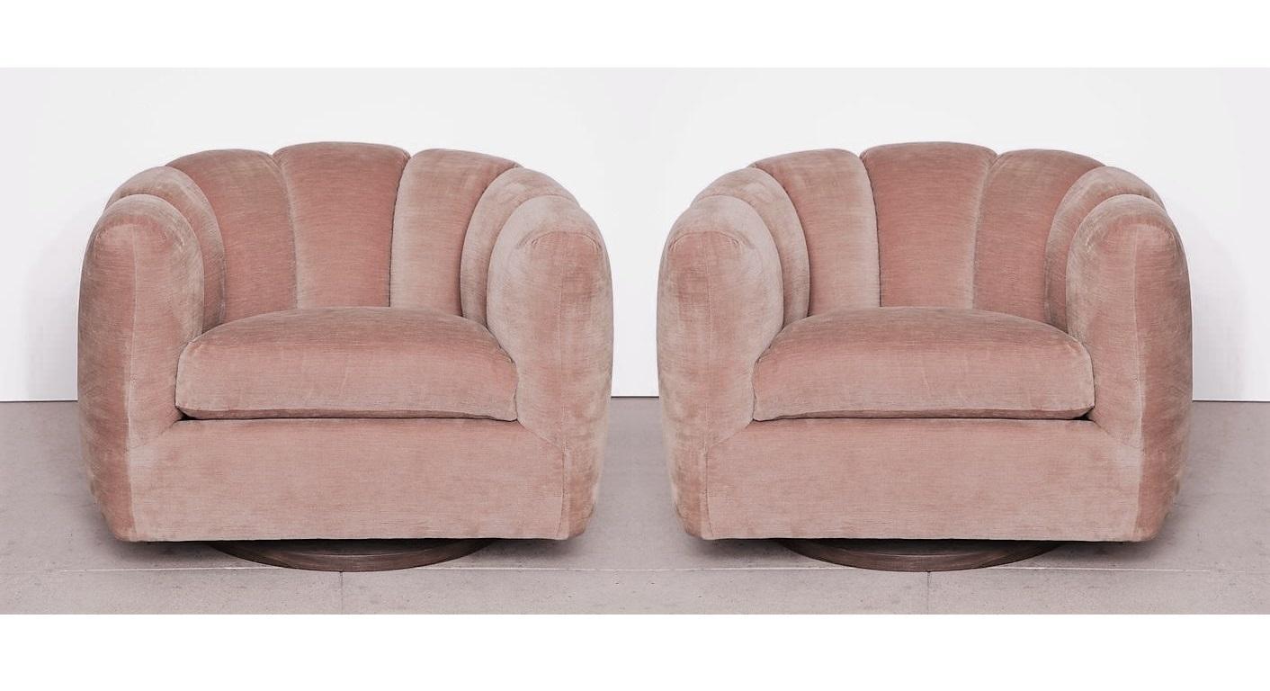 Pair of swivel chairs with channel backs attributed to Milo Baughman are well-cushioned and comfortable. The design is noteworthy for its channel back and rounded shape. Completely restored with a soft pink velvet tufted upholstery, supported on a