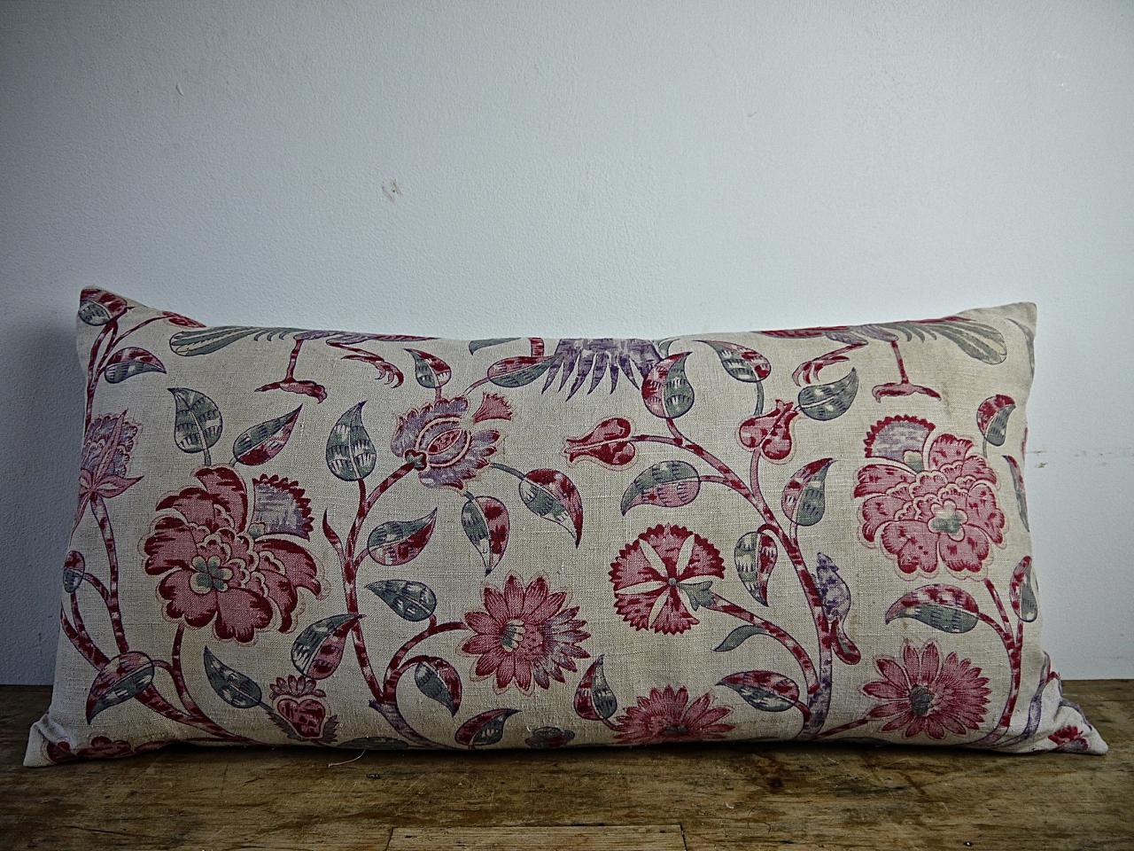 Pair of French late 19th century linen cushions printed with a large scale design of pink, red and pale mauve stylized flowers on arching branches and leaves with an glimpse of two exotic birds. Backed in a natural dye French linen and slip-stitched
