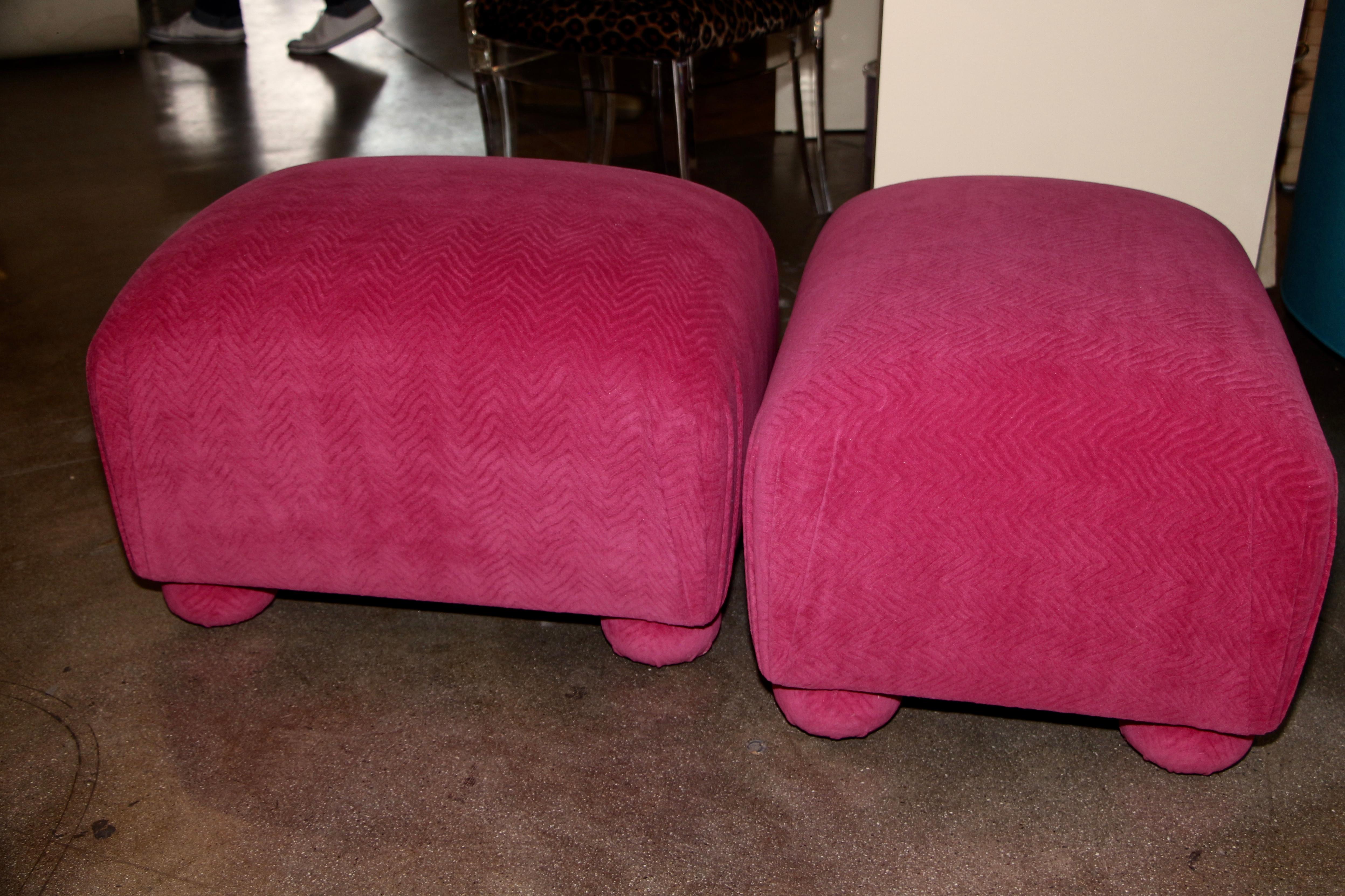 A nice pair of vintage ottomans re-upholstered in a beautiful pink Fuschia wool Mohair fabric, with a slight pattern to it. They are extremely sturdy. They can be used as stools as well for extra seating.