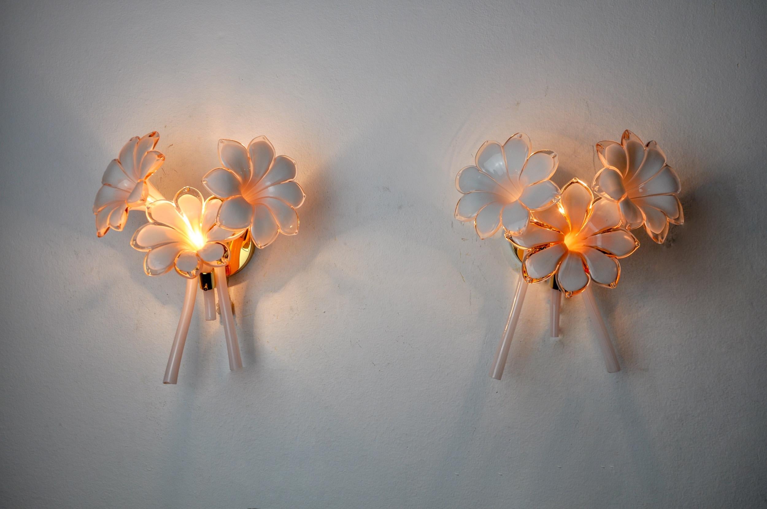 Superb and rare pair of fleur de lys wall lamps in murano glass, designed and produced in italy in the 1970s. Gilded metal structure composed of pink cut crystals in the shape of a fleur-de-lys, made by italian master glassmakers. Rare design object