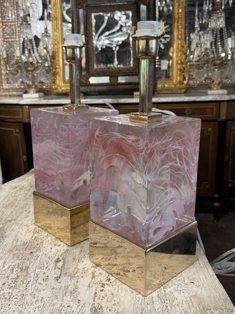 La paire de blocs-miroirs roses en verre de Murano et en laiton constitue un ajout stylé et élégant à toute décoration intérieure. L'association du verre rose de Murano et des blocs de laiton crée une finition unique et accrocheuse, parfaite pour