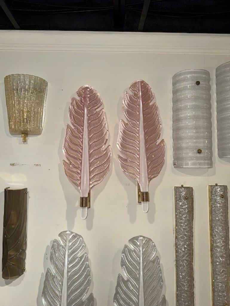 Questa inserzione presenta una coppia di moderne applique a forma di foglia in vetro di Murano, smerigliato con finitura rosa. Le appliques sono realizzate in vetro e conferiscono un aspetto lussuoso ed elegante. Il design a foglie aggiunge un tocco