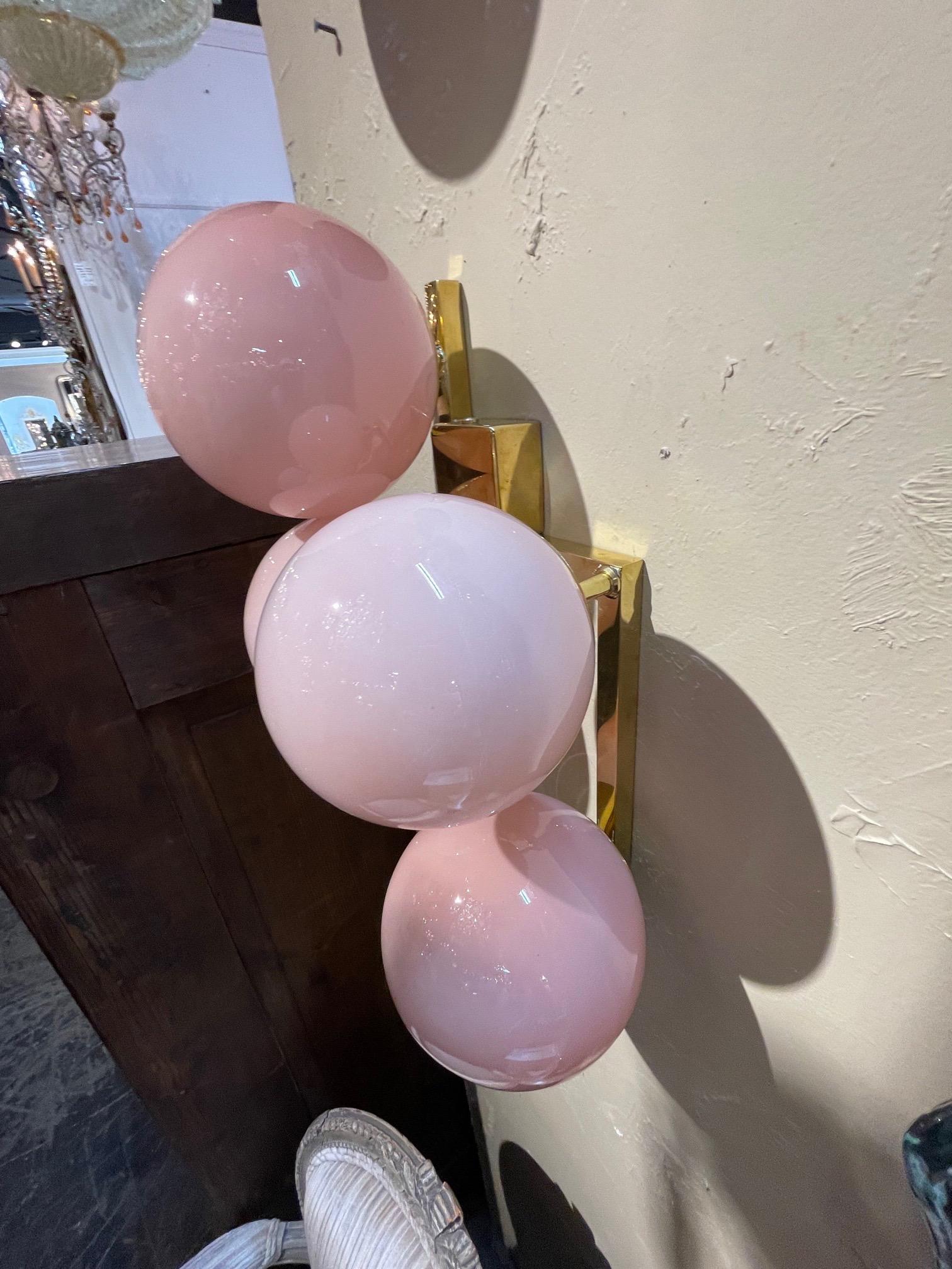 Decorative pair of pink Murano glass sphere and brass sconces. A unique pair that creates a real presence.