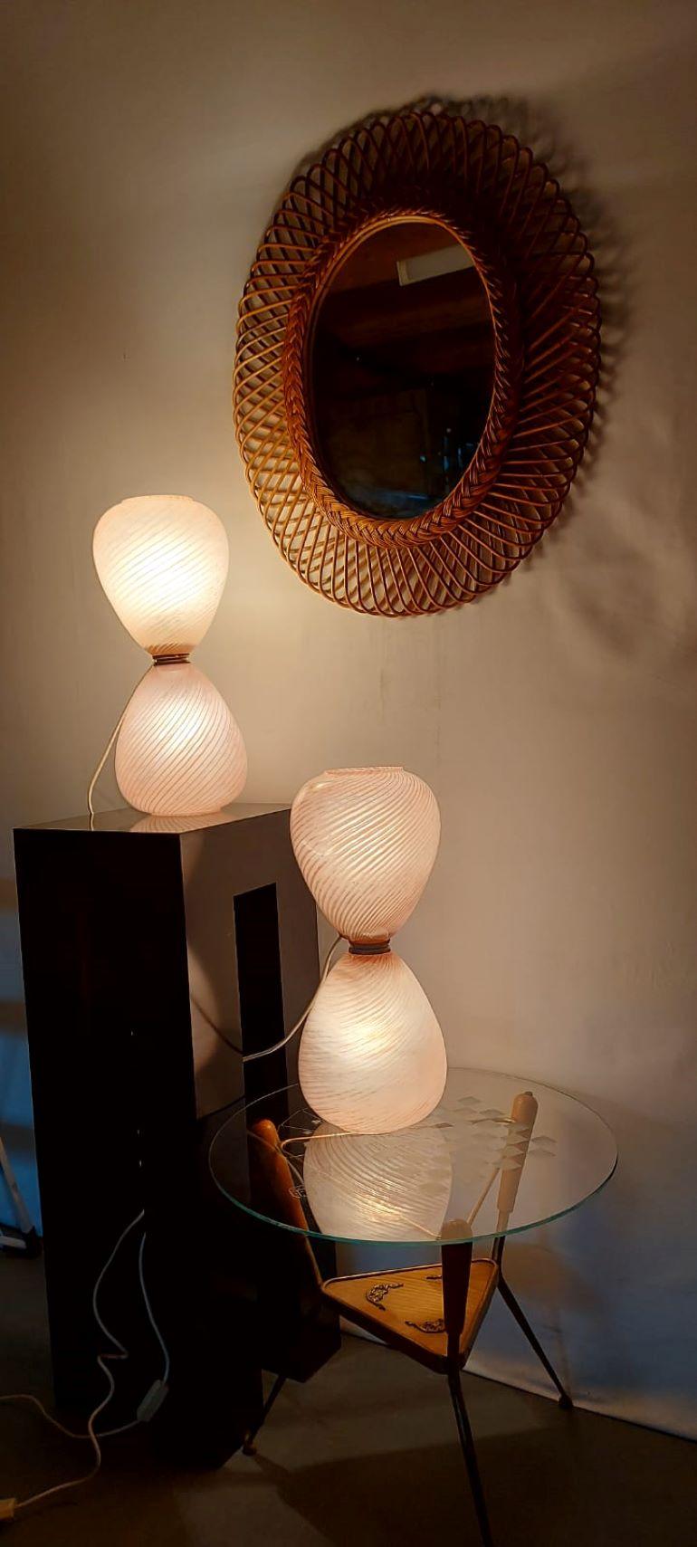 Pair of Pink Pale Blown Glass Murano Hourglass Table Lamps.
The hand blown glass has a torchon and ribbed effect.
Each lamp has two light bulbs one on the top and one at the bottom wich can be switched on alternately