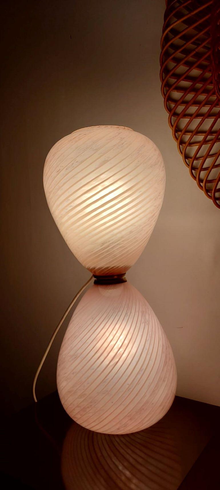 Pink Pale Blown Glass Murano Hourglass Table Lamp.
The hand blown glass has a torchon and ribbed effect.
The lamp has two light bulbs one on the top and one at the bottom which can be switched on alternately