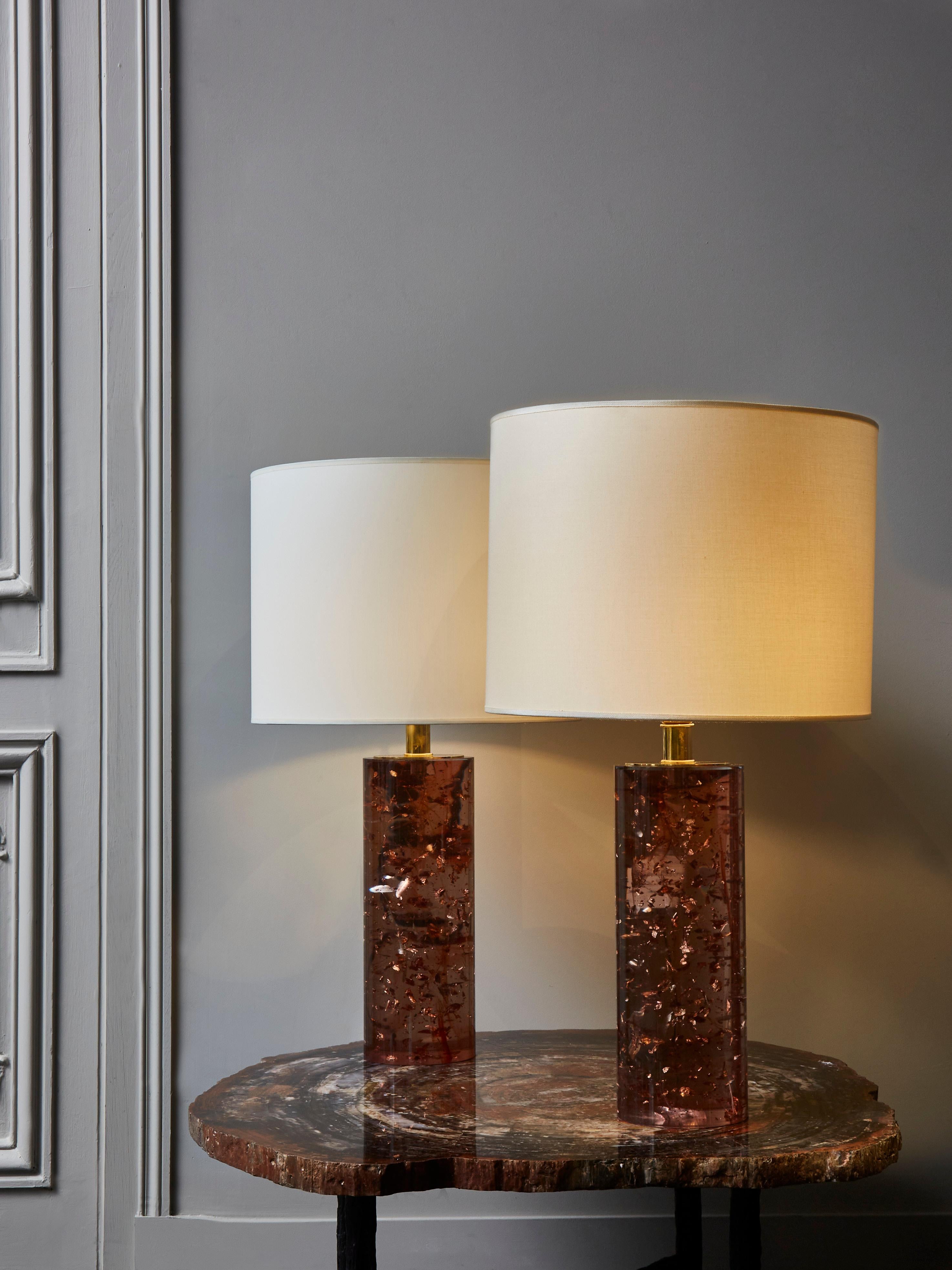 Pair of cylindrical table lamps, made of gold leaf set in pink resin.