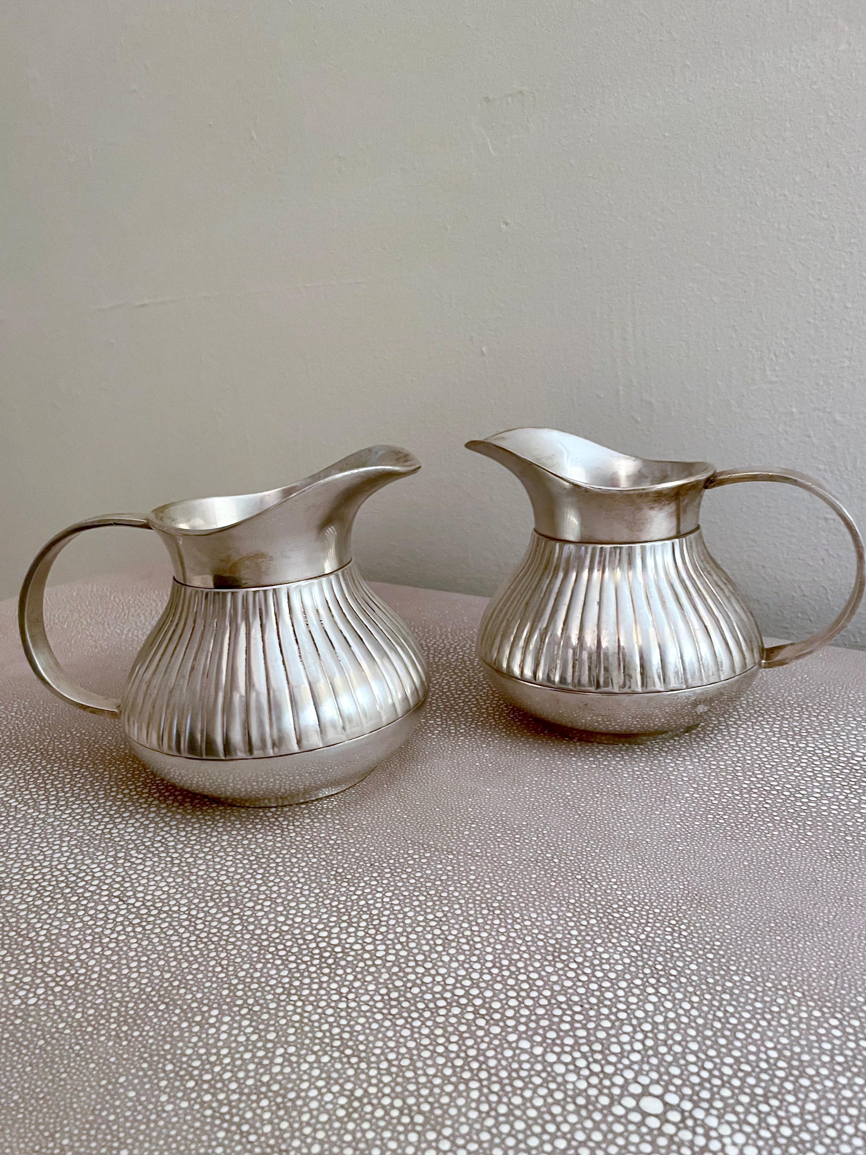 Metal Pair of Pinstriped Silver Pitchers For Sale