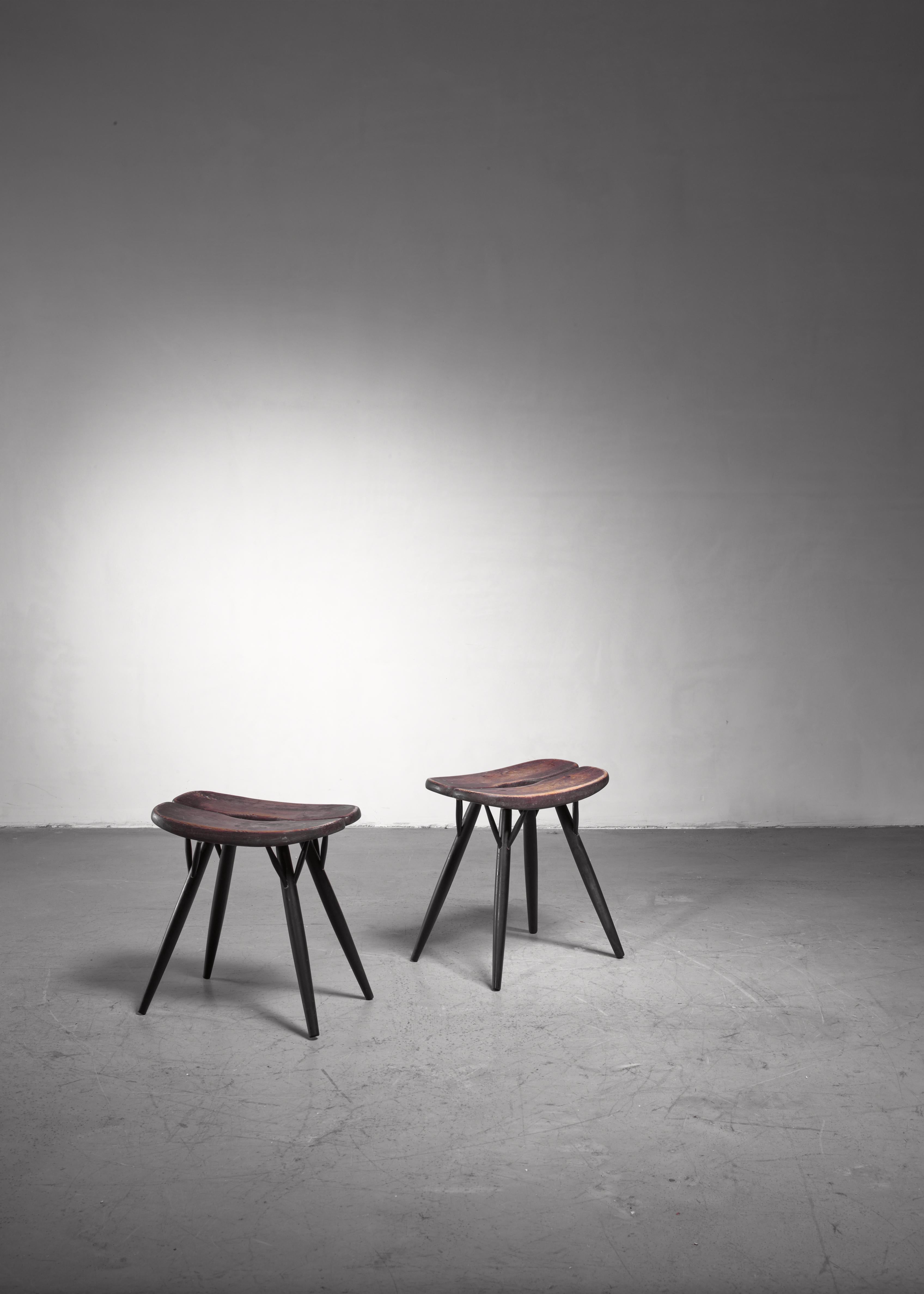 A pair of Finnish ebonized pine Ilmari Tapiovaara stools from the Pirkka series. The stools are branded by Tapiovaara and Laukaan Puu.
 