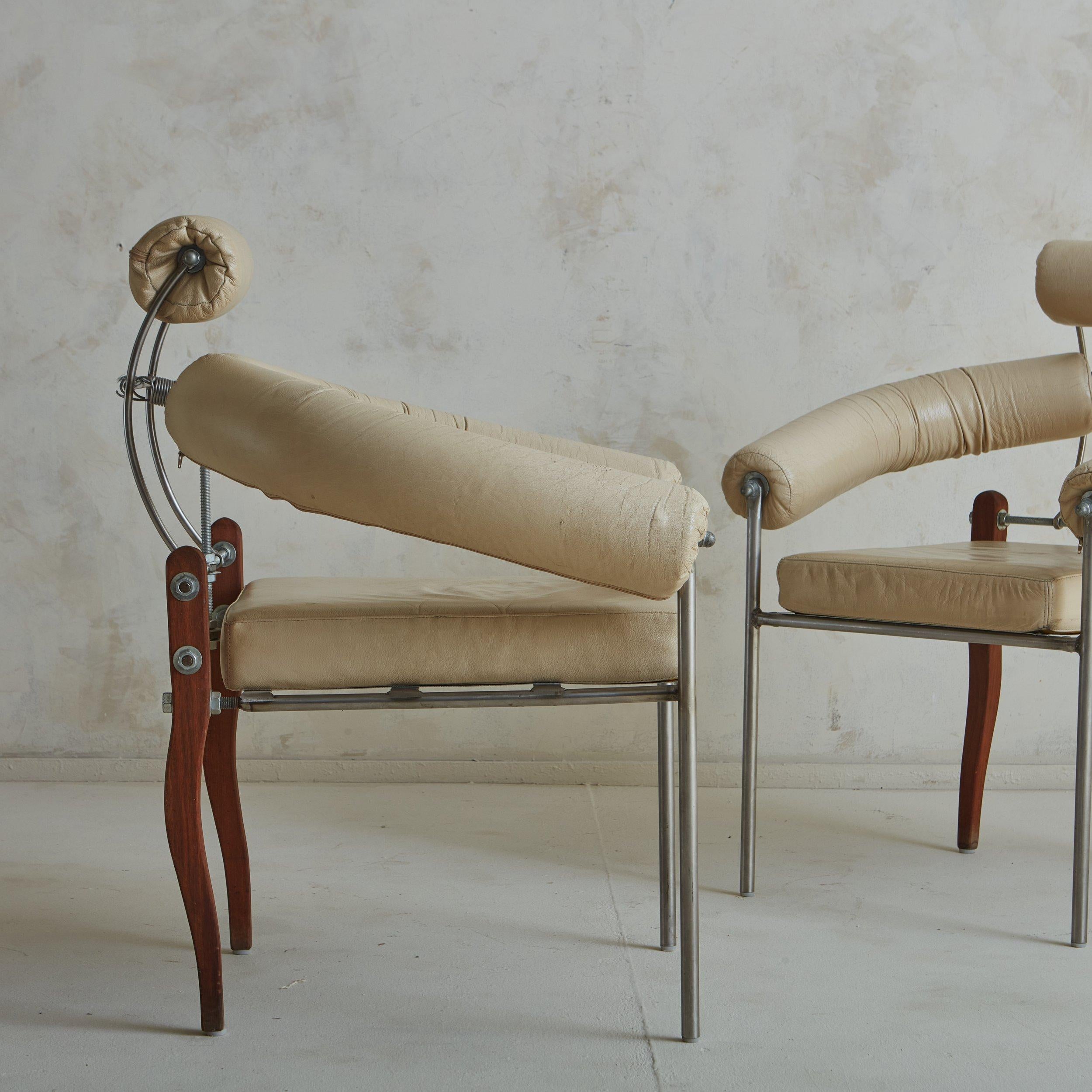 A pair of Swiss ‘Pirmin’ chairs designed by Heinz Julen in the 1990s. These sculptural chairs feature a variety of materials; they have industrial stainless steel frames with upholstered seats, arms and seat backs in original cream leather. The