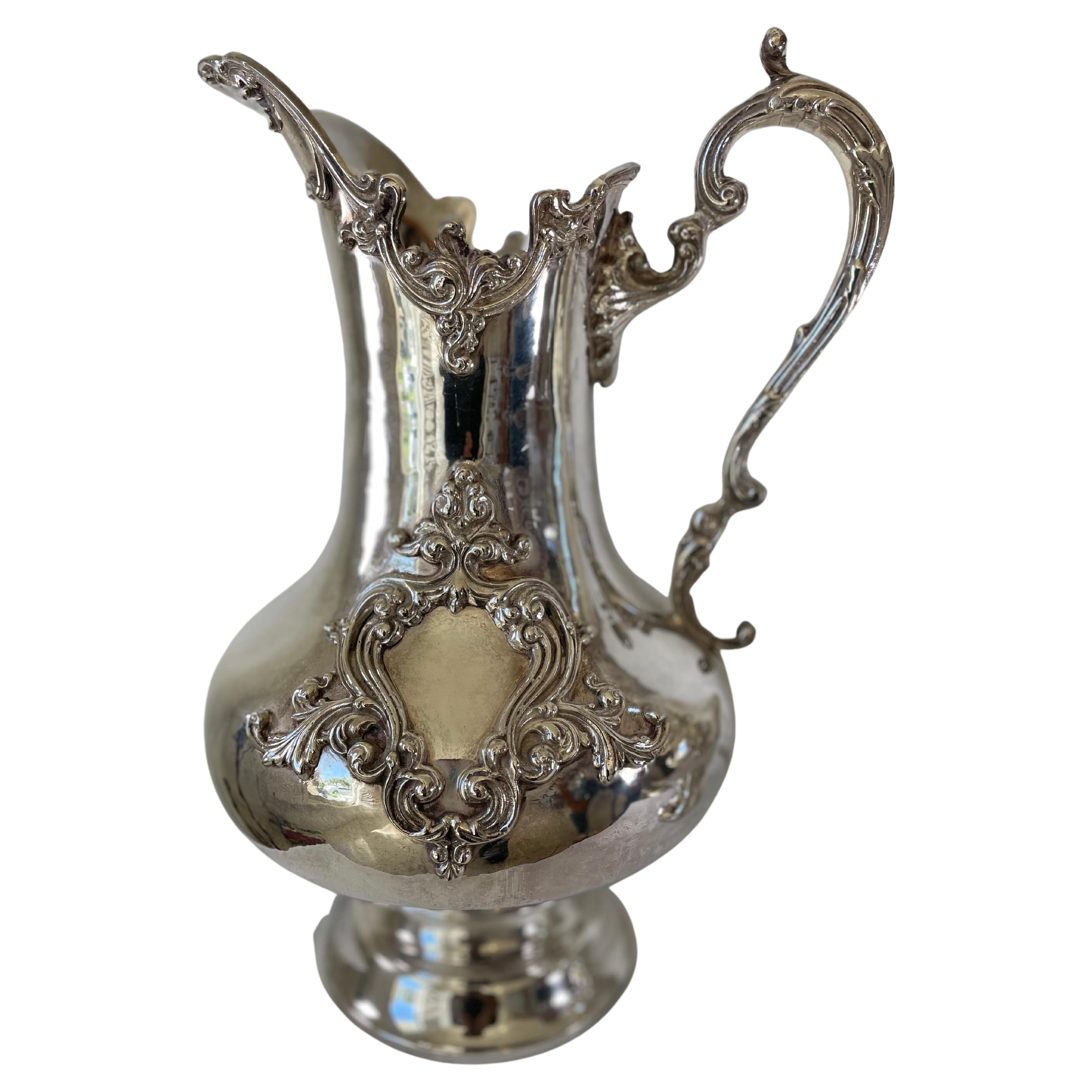 Pair of English pitchers signed Royal Castle Sheffield EP, on the underside. Pitchers in silver metal of large sizes decorated with foliage, on the handle, on the neck and a central decoration.