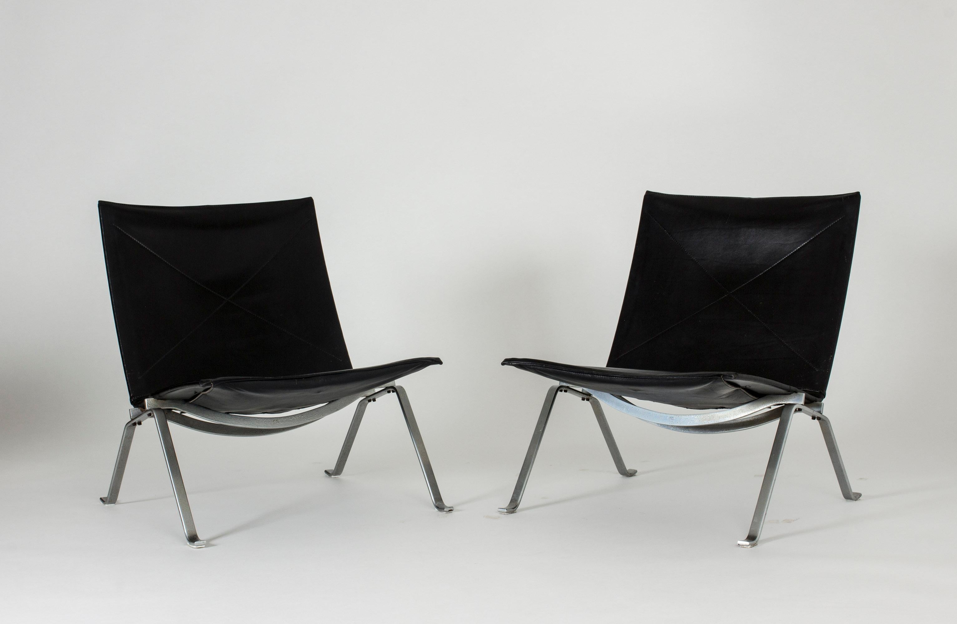Pair of “PK 22” lounge chairs by Poul Kjaerholm, made with very nice aged black leather and brushed steel frames. Made by original producer E. Kold Christensen.
