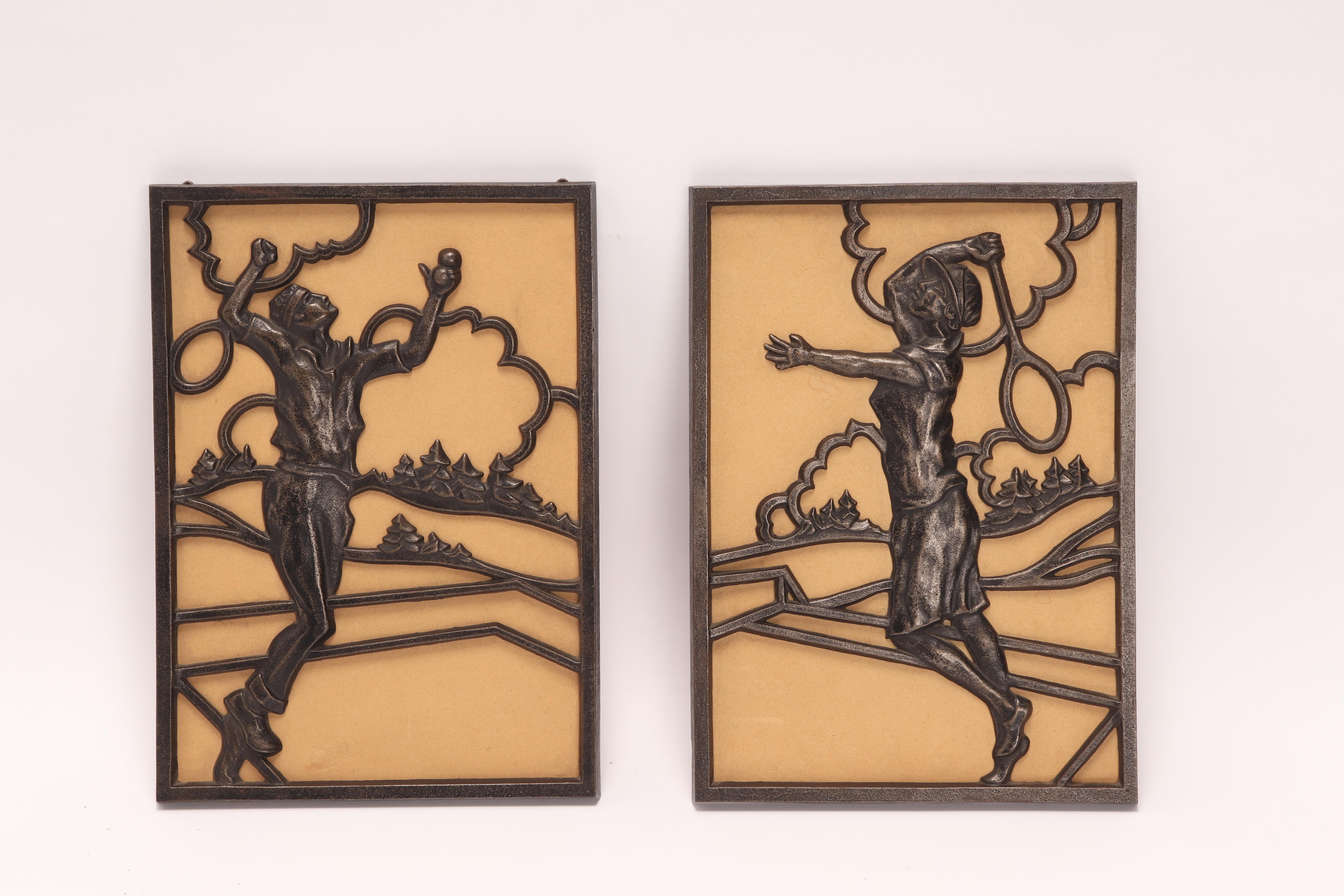 Pair of bronze plates, rectangular shape, openwork, depicting two tennis players, a man, and a woman, with pine trees and clouds in the background. Austria 1930 ca.
 