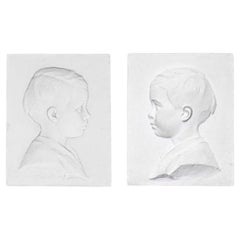 Paire de profils d'enfant en plâtre, 20e siècle.